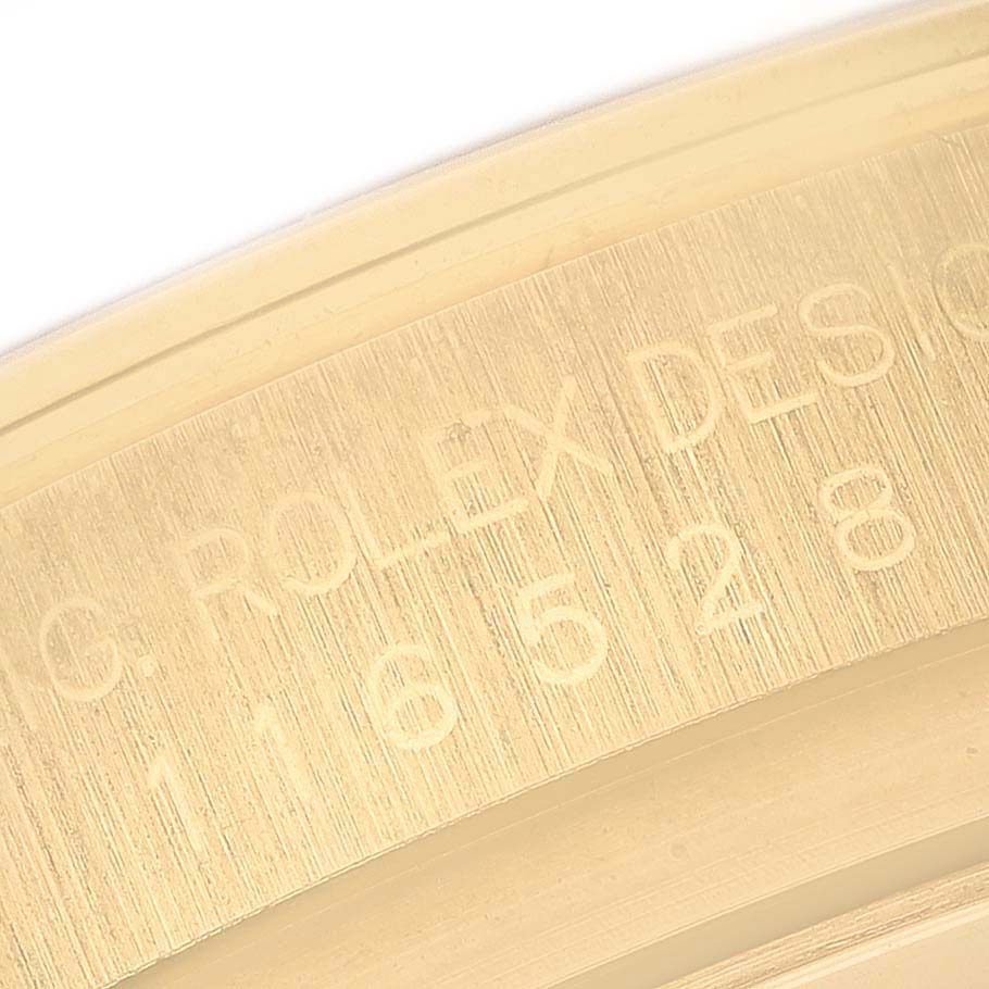 This close-up image shows the engraved inner bezel of a Rolex Daytona 116528 Men's Yellow Gold Champagne Dial 116528 Men's Yellow Gold Champagne Dial watch.