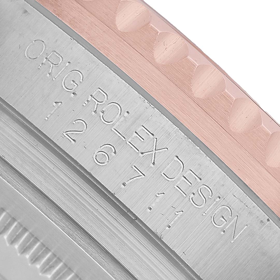 The image shows a close-up of the Rolex GMT-Master 126711 Men's Steel and Gold (two tone) Black Dial model, focusing on part of the case with engraved text.