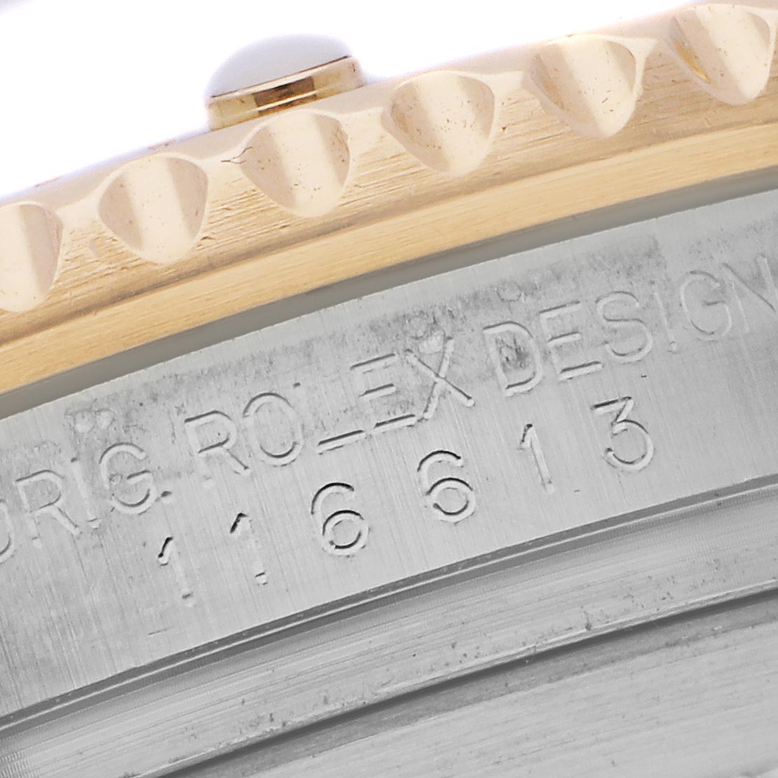 The image shows the side view of a Rolex Submariner 116613LB Men's Steel and Gold (two tone) Blue Dial 116613LB Men's Steel and Gold (two tone) Blue Dial, highlighting the engraved case number and part of the bezel edge.