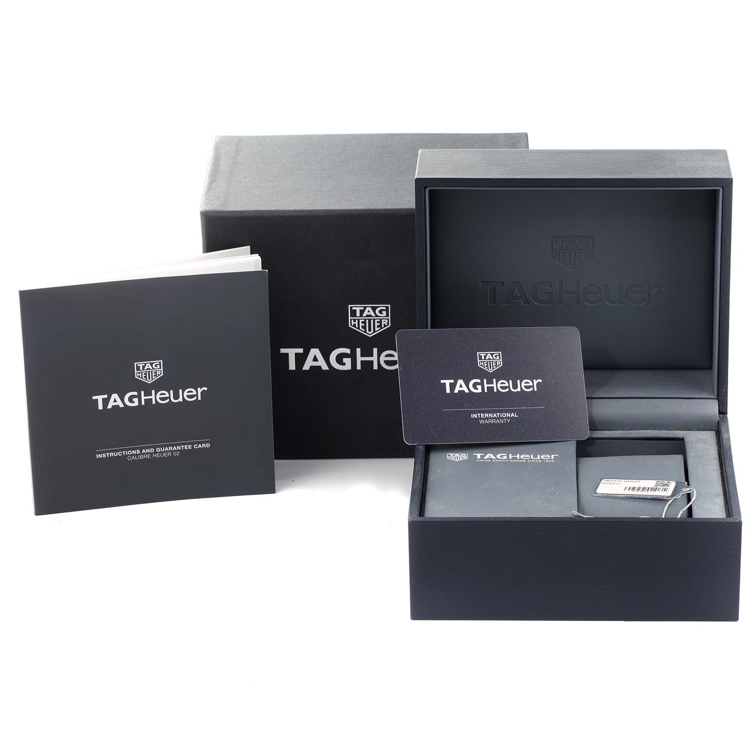 The image shows the packaging, instruction manual, and warranty card for a Tag Heuer Carrera CBN2A10.BA0643 Men's Stainless Steel Green Dial CBN2A10.BA0643 Men's Stainless Steel Green Dial watch.