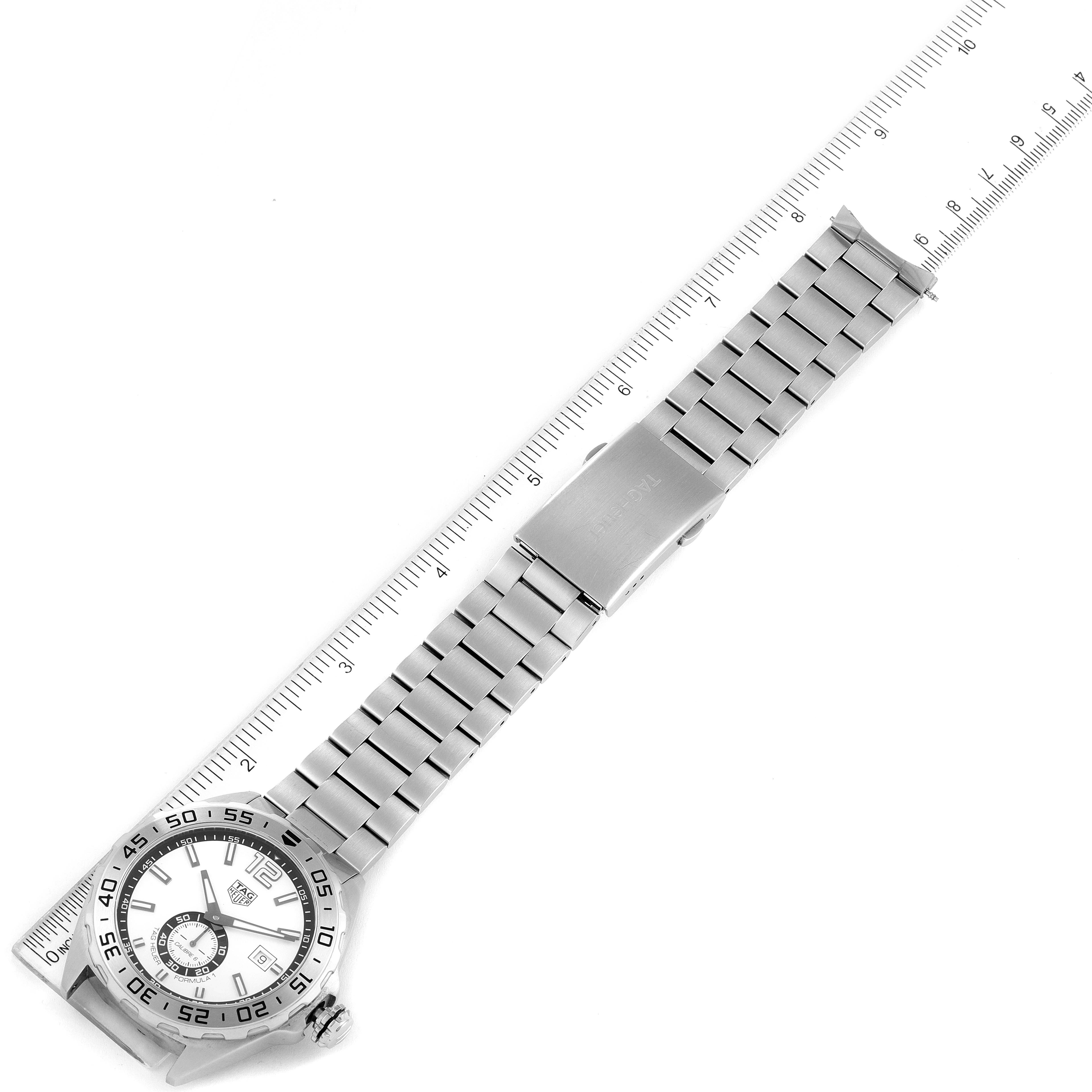 This image shows a Tag Heuer Formula 1 WAZ2013.BA0842 Men's Stainless Steel White Dial WAZ2013.BA0842 Men's Stainless Steel White Dial watch laid flat, including the face, bezel, bracelet, and clasp, with a ruler for scale.