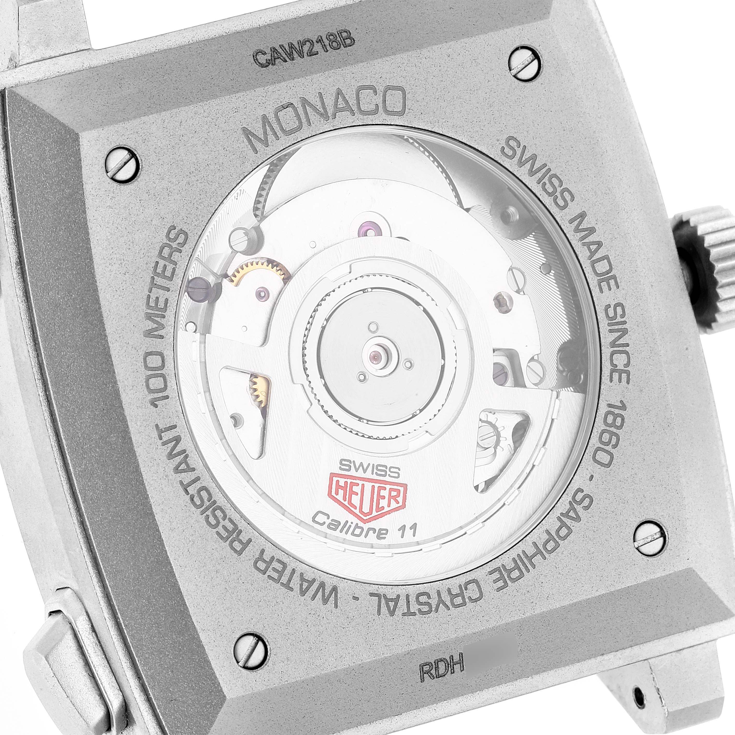 The image shows the case back of the Tag Heuer Monaco CAW218B.FC6496 Men's Titanium Silver Dial CAW218B.FC6496 Men's Titanium Silver Dial watch, revealing the inner movement and various engravings.