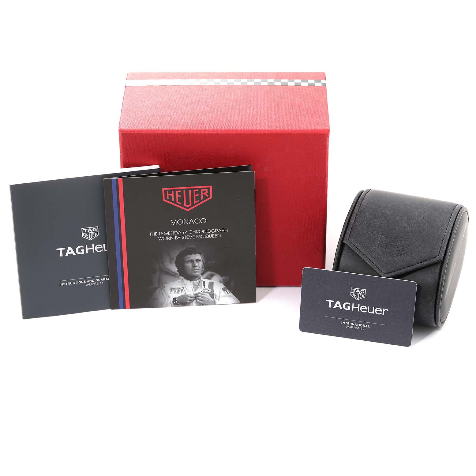 The image shows the Tag Heuer Monaco CAW218B.FC6496 Men's Titanium Silver Dial CAW218B.FC6496 Men's Titanium Silver Dial watch's packaging, including a red box, travel case, instruction manual, and warranty card.
