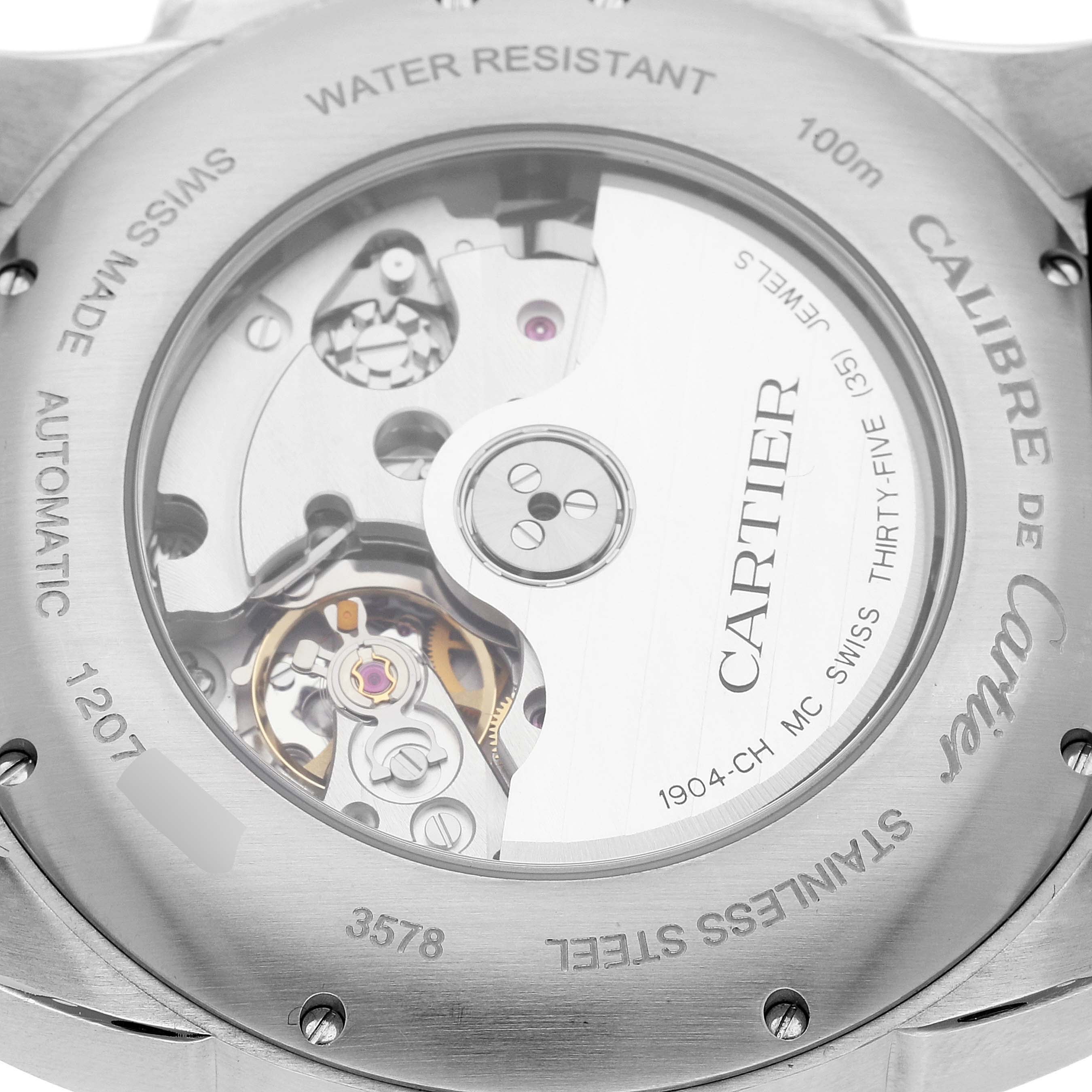 The image shows the back of a Calibre de Cartier watch by Cartier, revealing its automatic movement and stainless steel case.