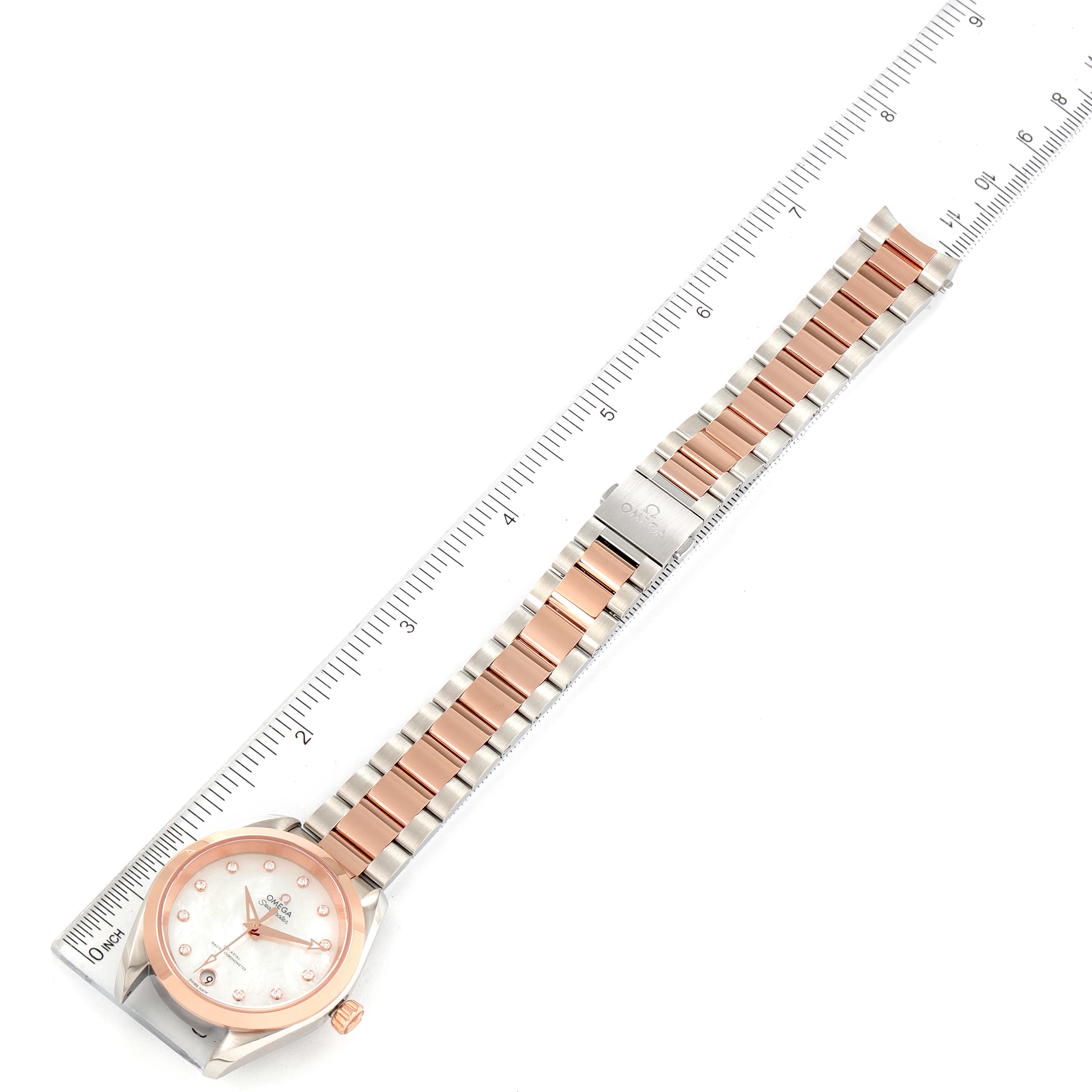 The image shows an overhead view of the Omega 220.20.34.20.55.001 Women's Steel and Gold (two tone) Mother of Pearl Dial 220.20.34.20.55.001 Women's Steel and Gold (two tone) Mother of Pearl Dial Aqua Terra Sedna Gold Diamond Ladies Watch 220.20.34.20.55.001 with a ruler for scale.