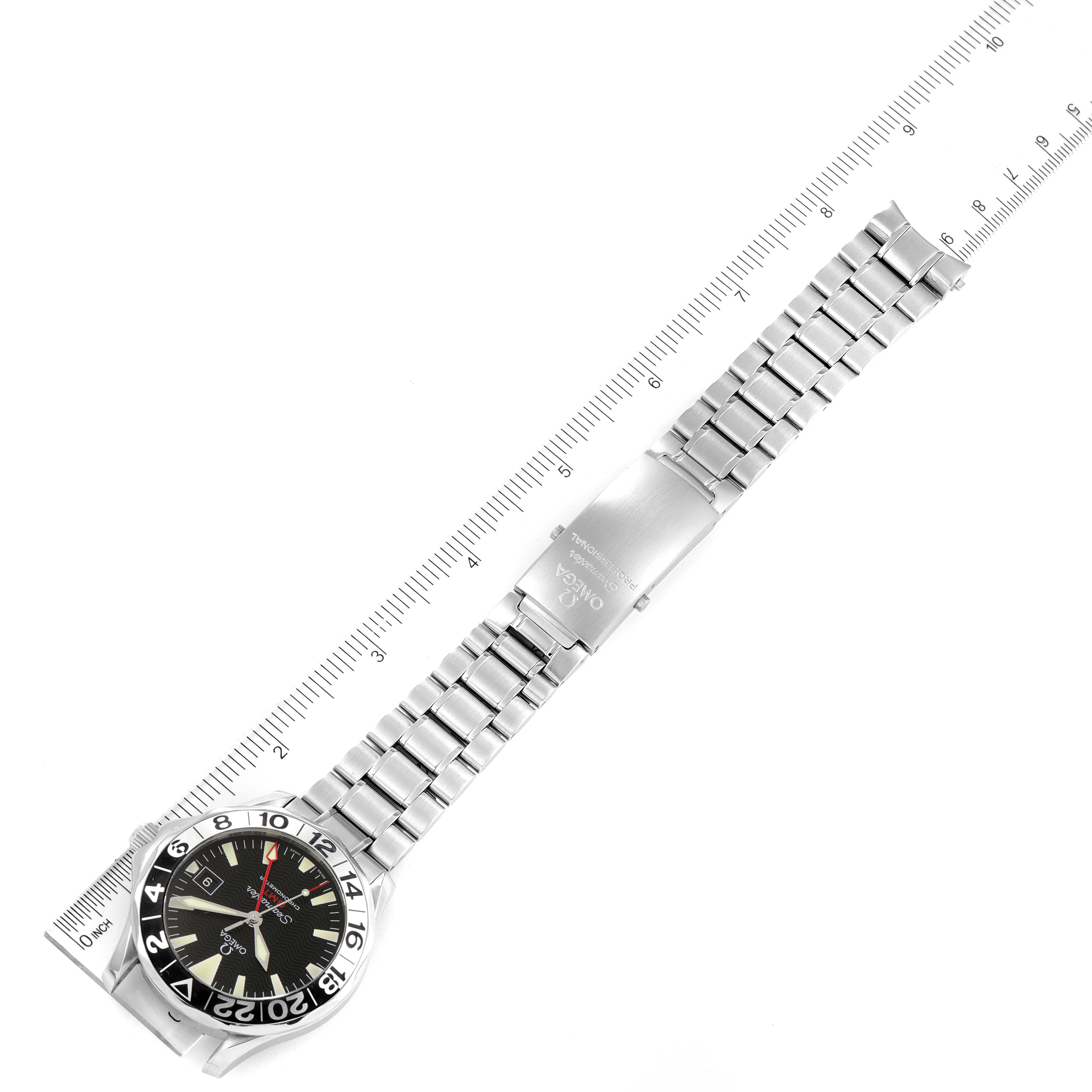 The Seamaster Omega watch is shown from a top-down angle, displaying its face, bracelet, and clasp, next to a ruler for size reference.