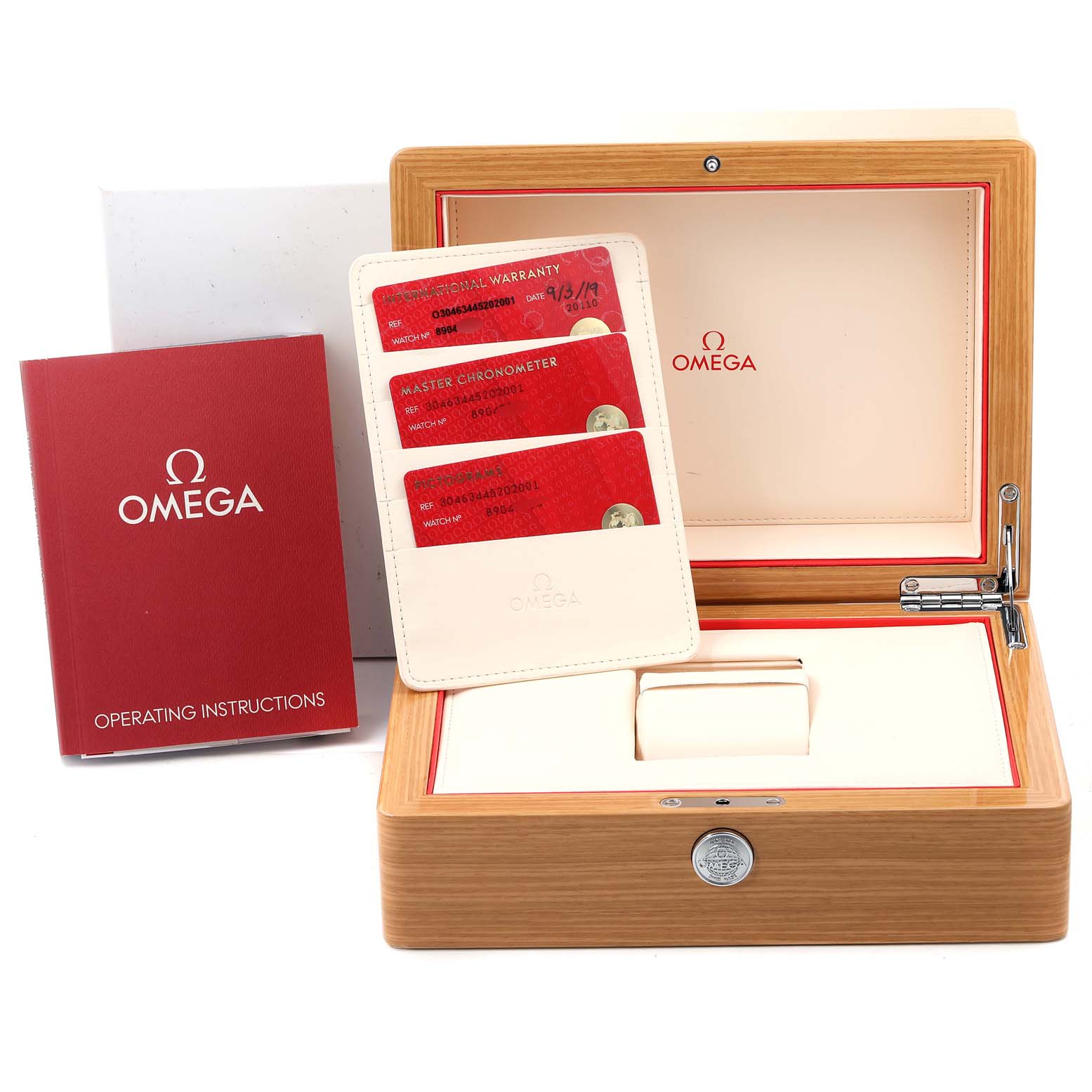 The image shows an Omega Speedmaster 304.63.44.52.02.001  Men's Yellow Gold Silver Dial 304.63.44.52.02.001  Men's Yellow Gold Silver Dial watch box, warranty cards, and the operating instructions manual.