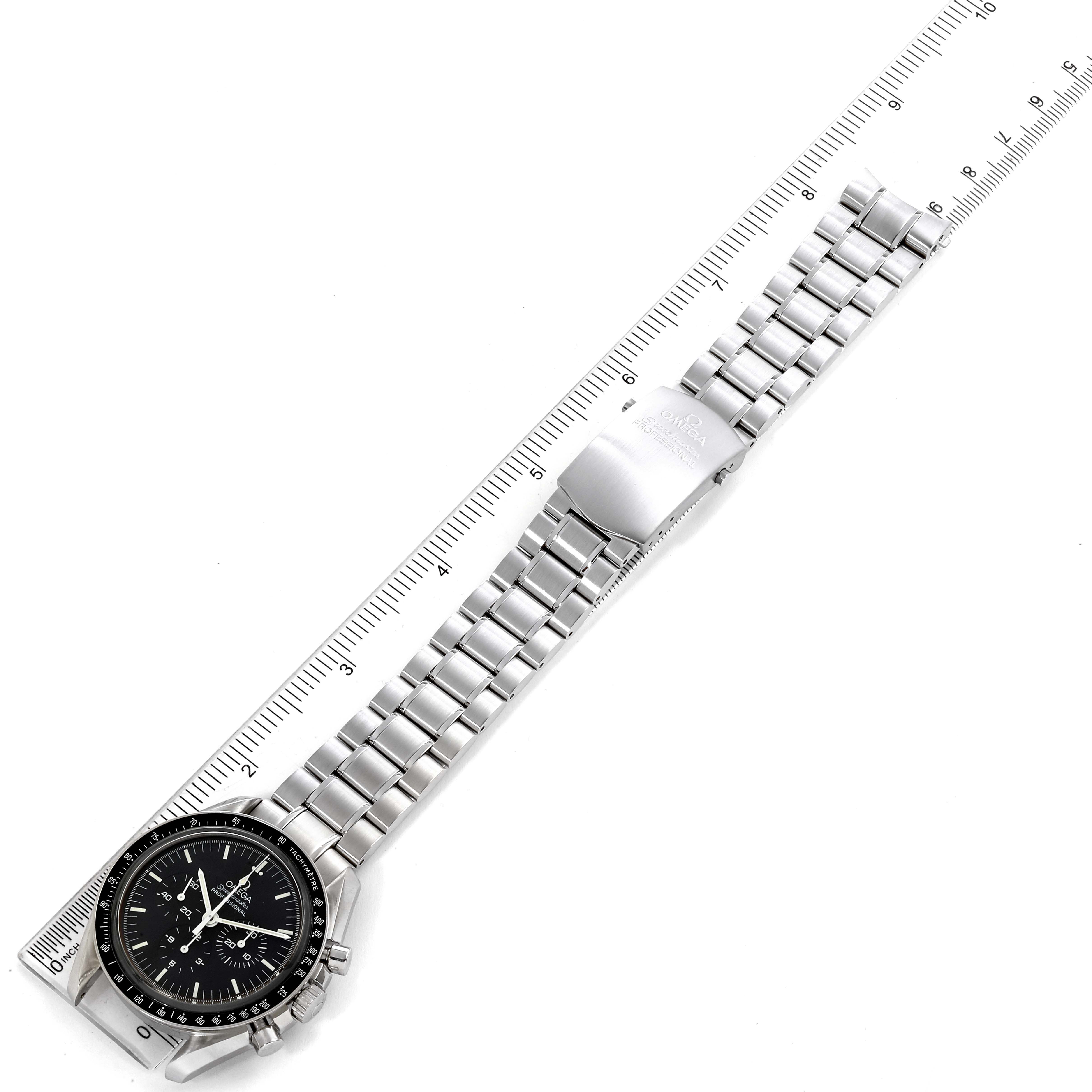 This image shows an overhead view of an Omega Speedmaster 3573.50.00 Men's Stainless Steel Black Dial 3573.50.00 Men's Stainless Steel Black Dial watch, highlighting its metal bracelet with a clasp and a ruler for scale.