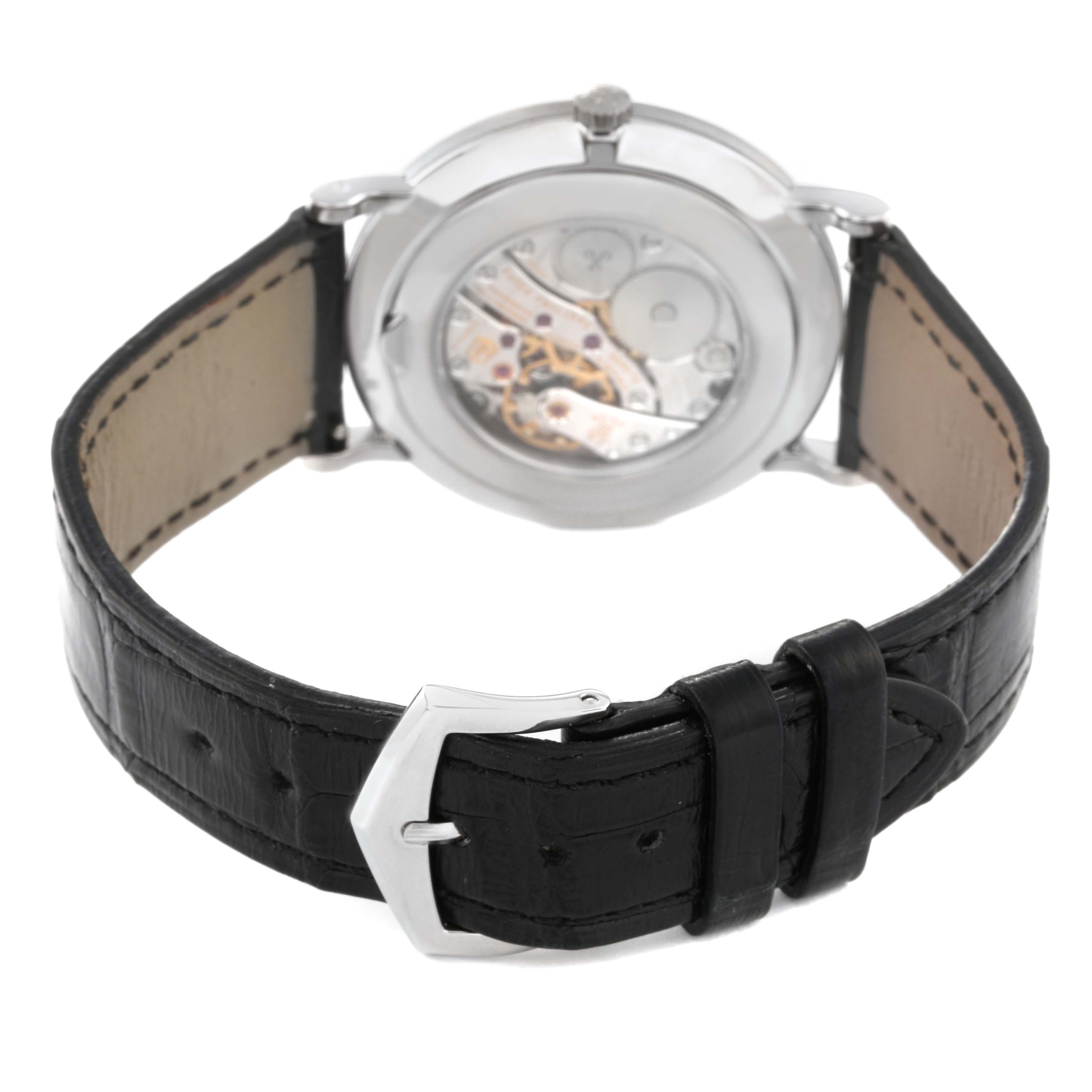 The image shows the back view of a Patek Philippe Calatrava 5119G-001 Men
s White Gold White Dial 5119G-001 Men
s White Gold White Dial watch, highlighting its open caseback and leather strap with a buckle.