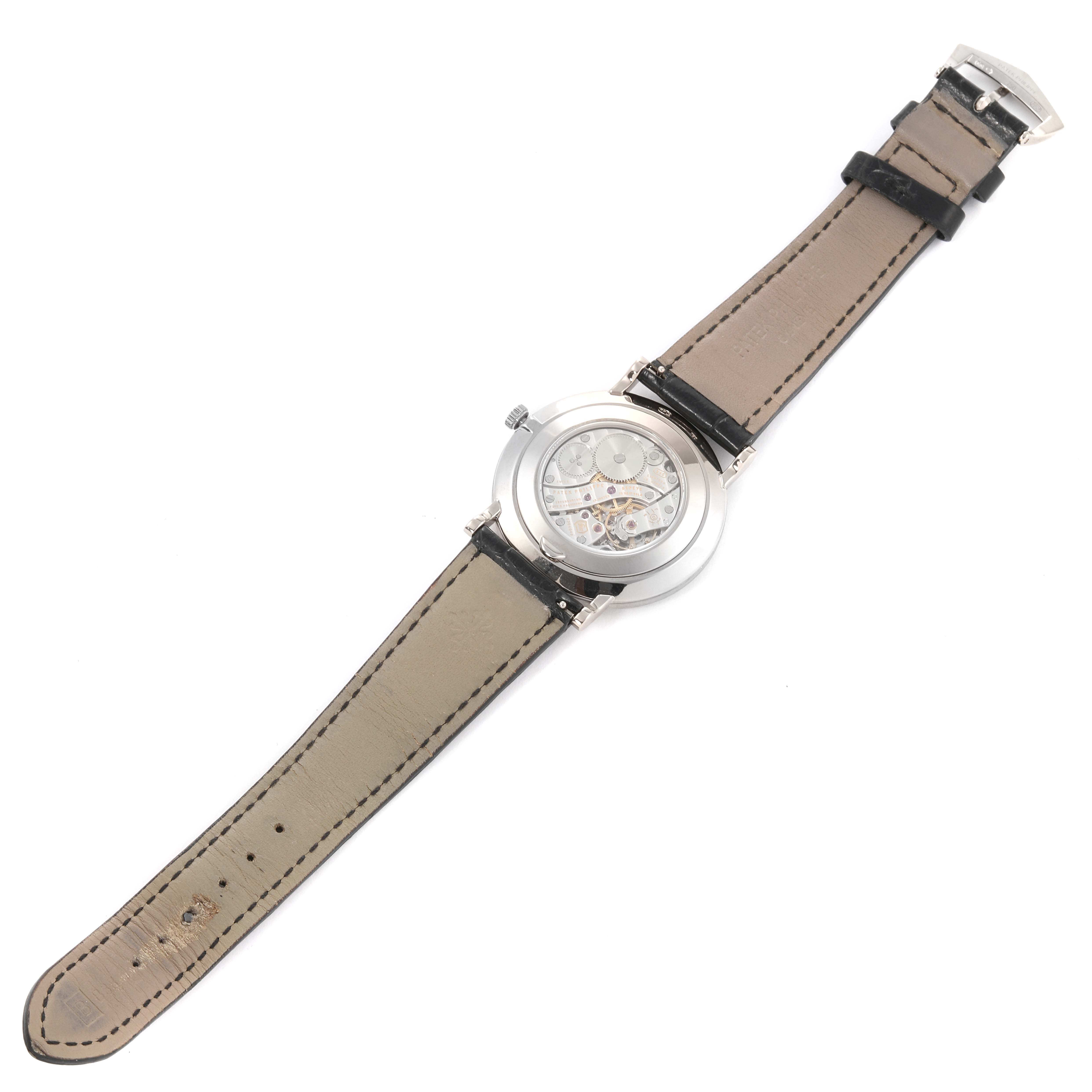 The image shows the back view of a Patek Philippe Calatrava 5119G-001 Men
s White Gold White Dial 5119G-001 Men
s White Gold White Dial watch, highlighting its leather strap and open case back.