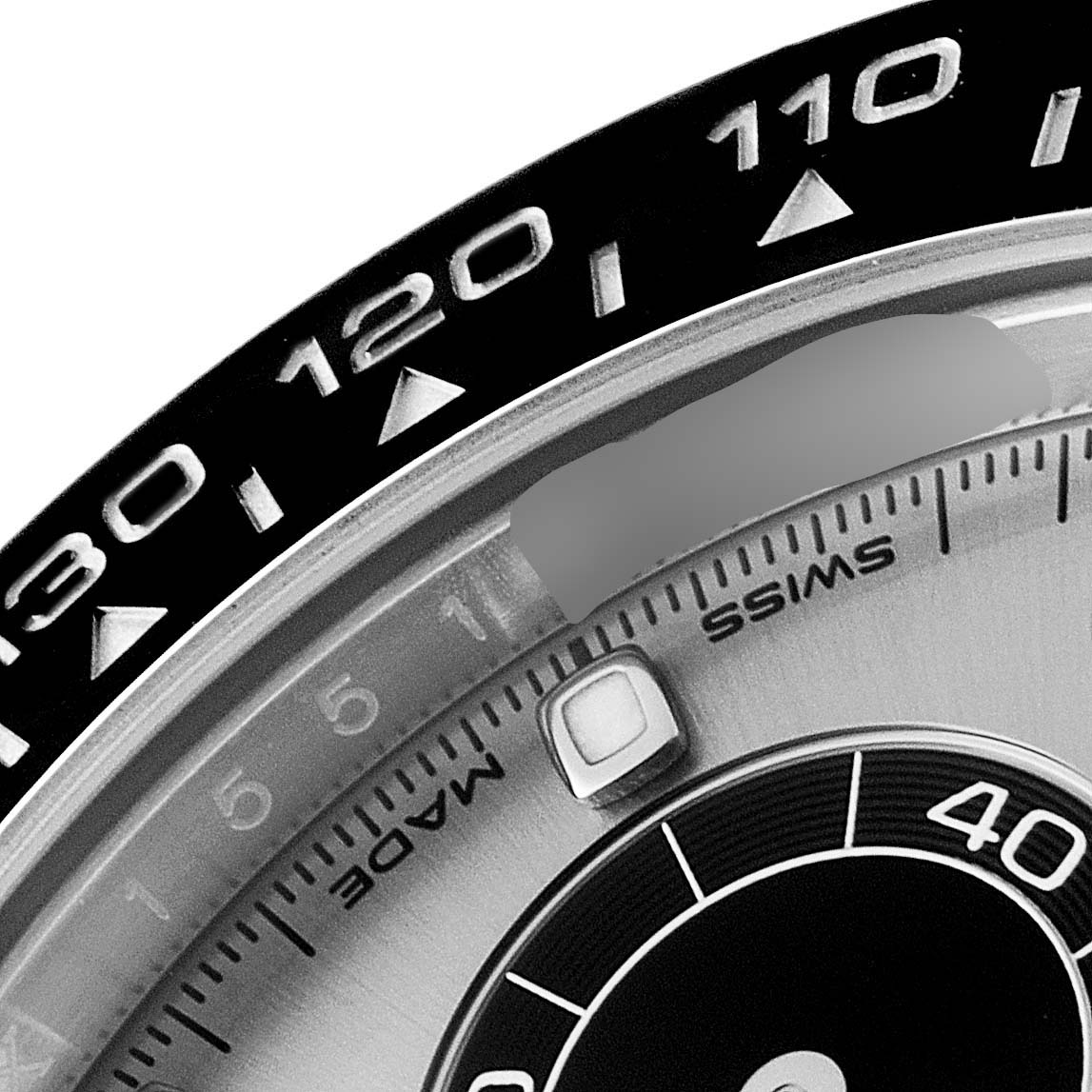 Close-up of the bezel and dial of a Rolex Daytona 116519 Men's White Gold Grey Dial 116519 Men's White Gold Grey Dial watch, showing part of the tachymeter scale and "SWISS MADE" text.