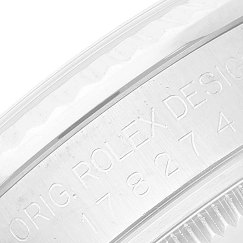 This image shows an engraved part of the bezel of a Mid-Size Rolex watch from a close-up angle.