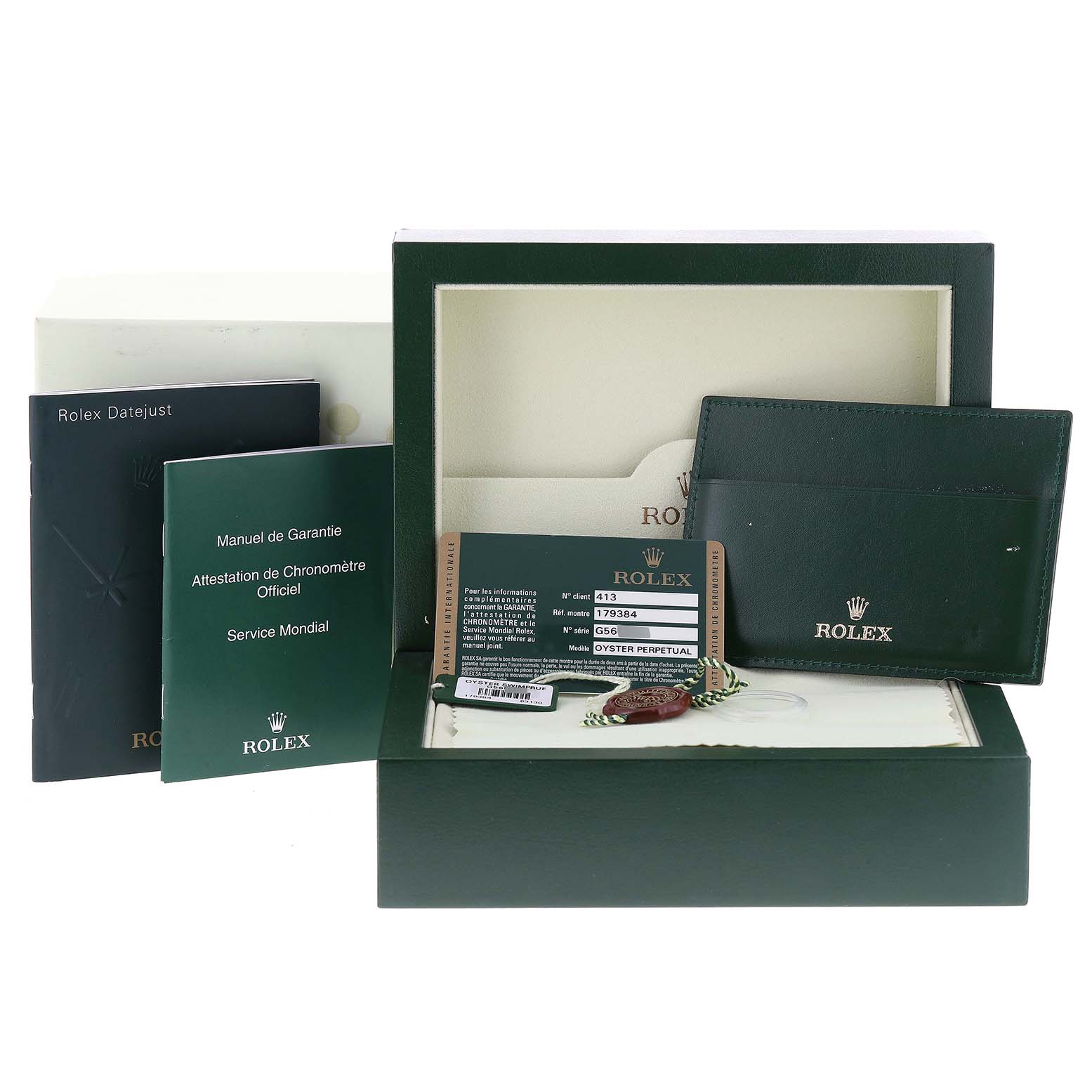This image shows the accessories of the Rolex Datejust 179384 Women's Stainless Steel Silver Dial 179384 Women's Stainless Steel Silver Dial model, including the box, warranty card, manuals, and a green cardholder.