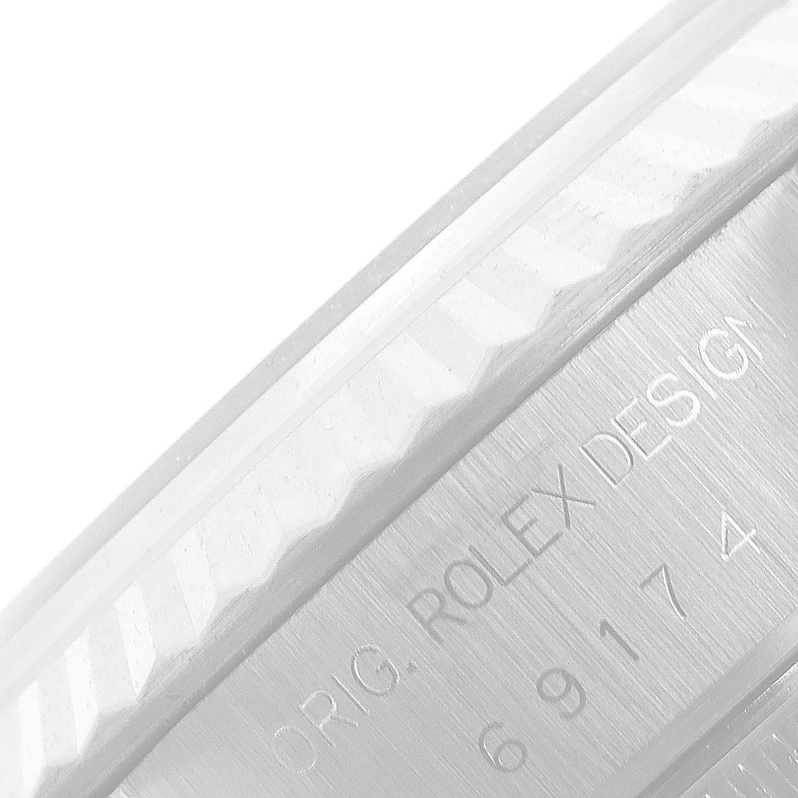 This image shows a close-up of the bezel and engraved serial number of a Rolex Datejust 69174 Women
s Stainless Steel Silver Dial 69174 Women
s Stainless Steel Silver Dial watch.