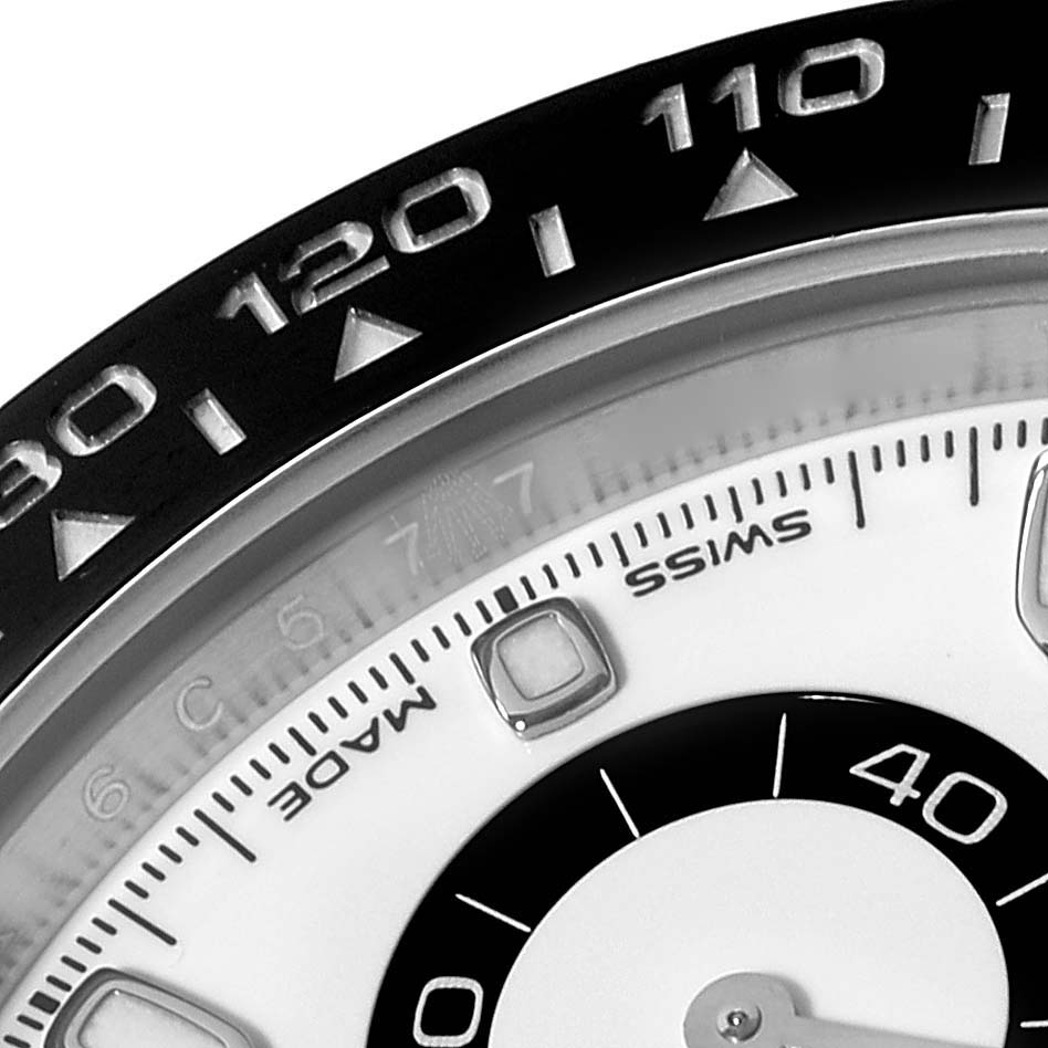 This close-up photo of a Rolex Daytona 116500LN Men's Stainless Steel White Dial 116500LN Men's Stainless Steel White Dial watch shows part of the bezel with the tachymeter scale and part of the dial.