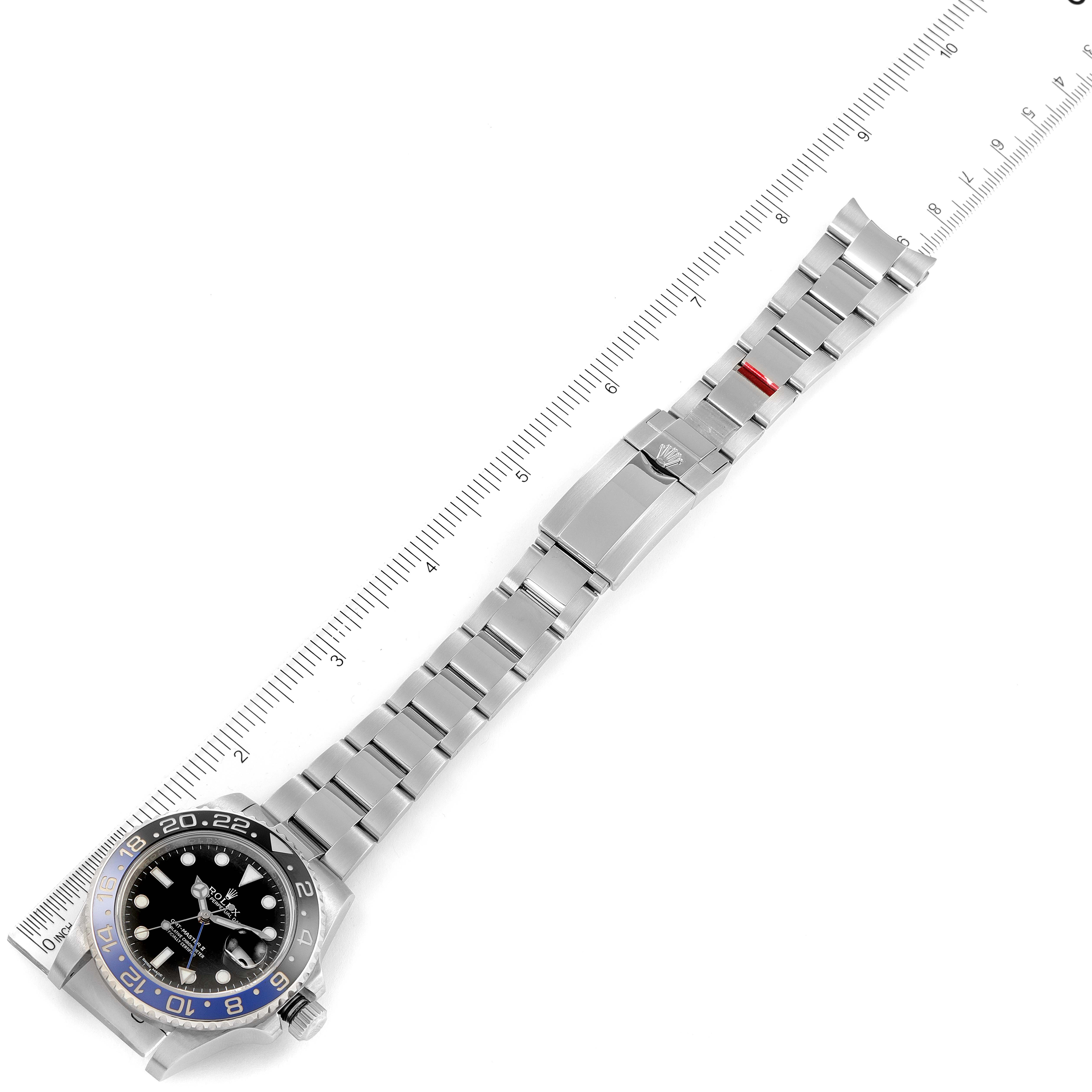 The image displays a top-down view of a Rolex GMT-Master 116710BLNR Men's Stainless Steel Black Dial 116710BLNR Men's Stainless Steel Black Dial watch with its stainless steel bracelet extended and a ruler for size reference.