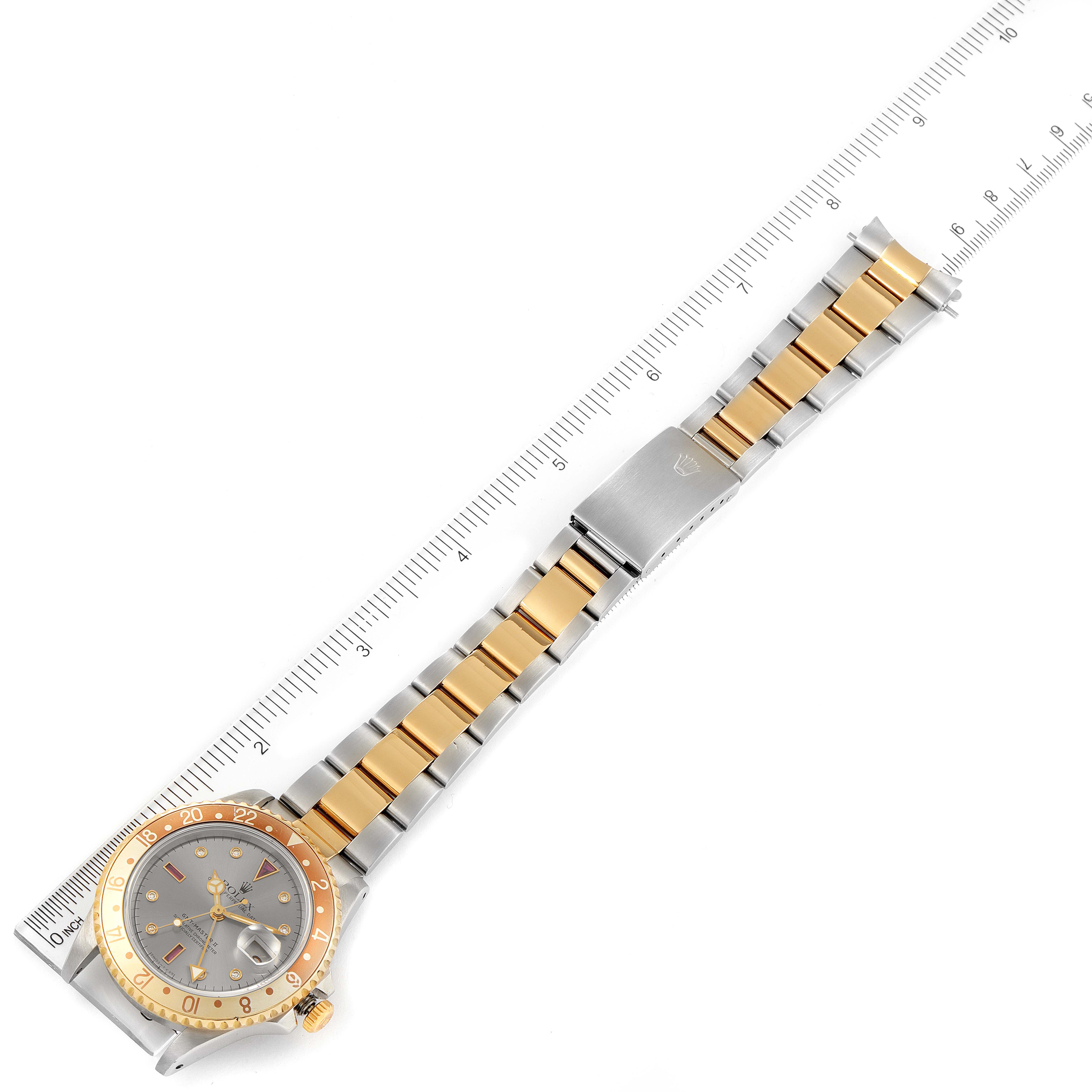 The Rolex GMT-Master 16713 Men's Steel and Gold (two tone) Grey Dial 16713 Men's Steel and Gold (two tone) Grey Dial watch is shown from a top-down angle, detailing its two-tone bracelet, clasp, and bezel.