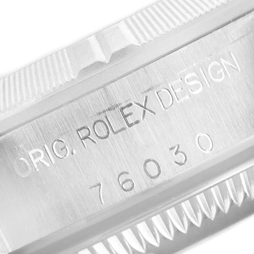 This close-up image shows the side engraving on the case of the Rolex Oyster Perpetual 76030 Women's Stainless Steel Black Dial 76030 Women's Stainless Steel Black Dial watch, displaying "ORIG. ROLEX DESIGN" and a model number.