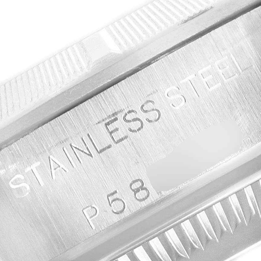 This close-up image shows the side of the bezel and the engraved "STAINLESS STEEL" on the case of a Rolex Oyster Perpetual 76030 Women's Stainless Steel Black Dial 76030 Women's Stainless Steel Black Dial watch.