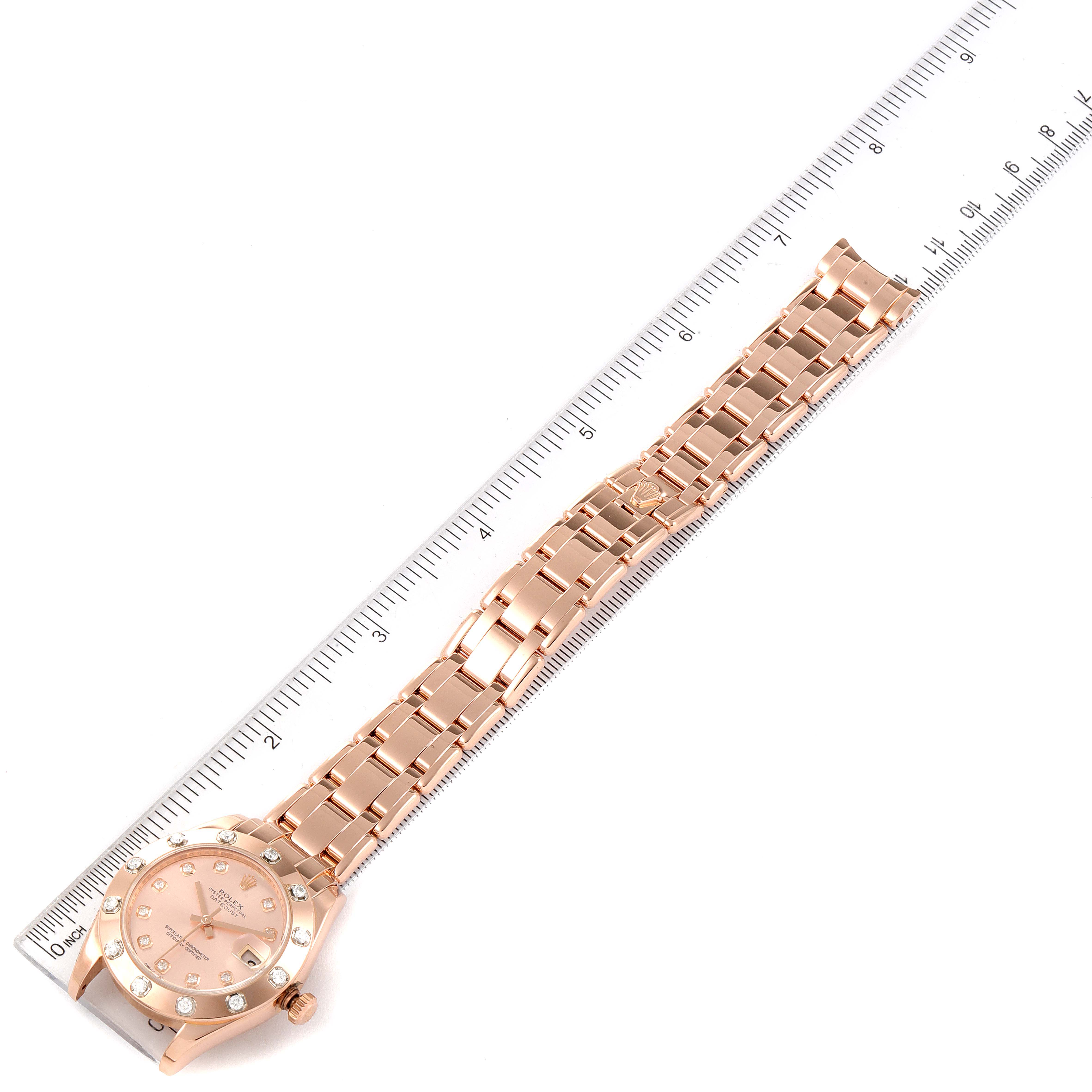 The image shows a Rolex Pearlmaster 81315 Women
s Rose Gold Pink Dial 81315 Women
s Rose Gold Pink Dial watch laid flat with its full bracelet next to a ruler for measurement.