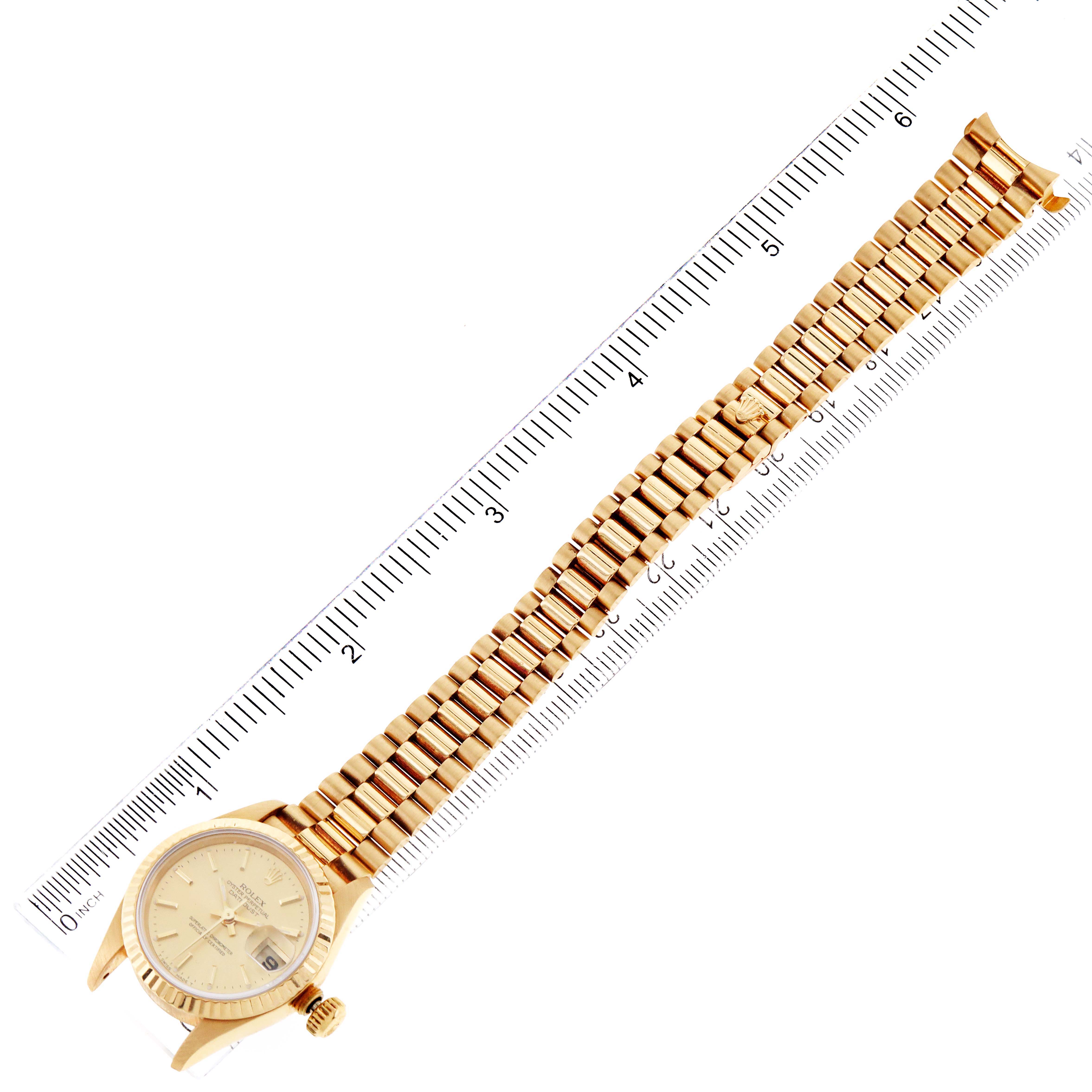 The image shows a Rolex President 69178 Women's Yellow Gold Champagne Dial 69178 Women's Yellow Gold Champagne Dial watch placed diagonally with its gold bracelet fully extended against a ruler for scale.