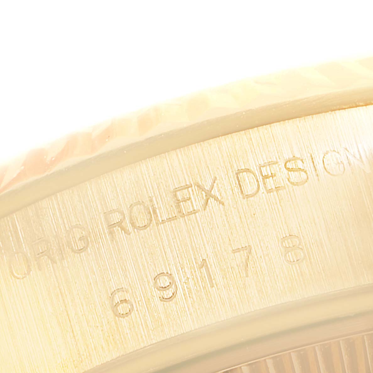 The image shows a close-up angle of the edge and engraved text on a Rolex President 69178 Women's Yellow Gold Champagne Dial 69178 Women's Yellow Gold Champagne Dial model watch.