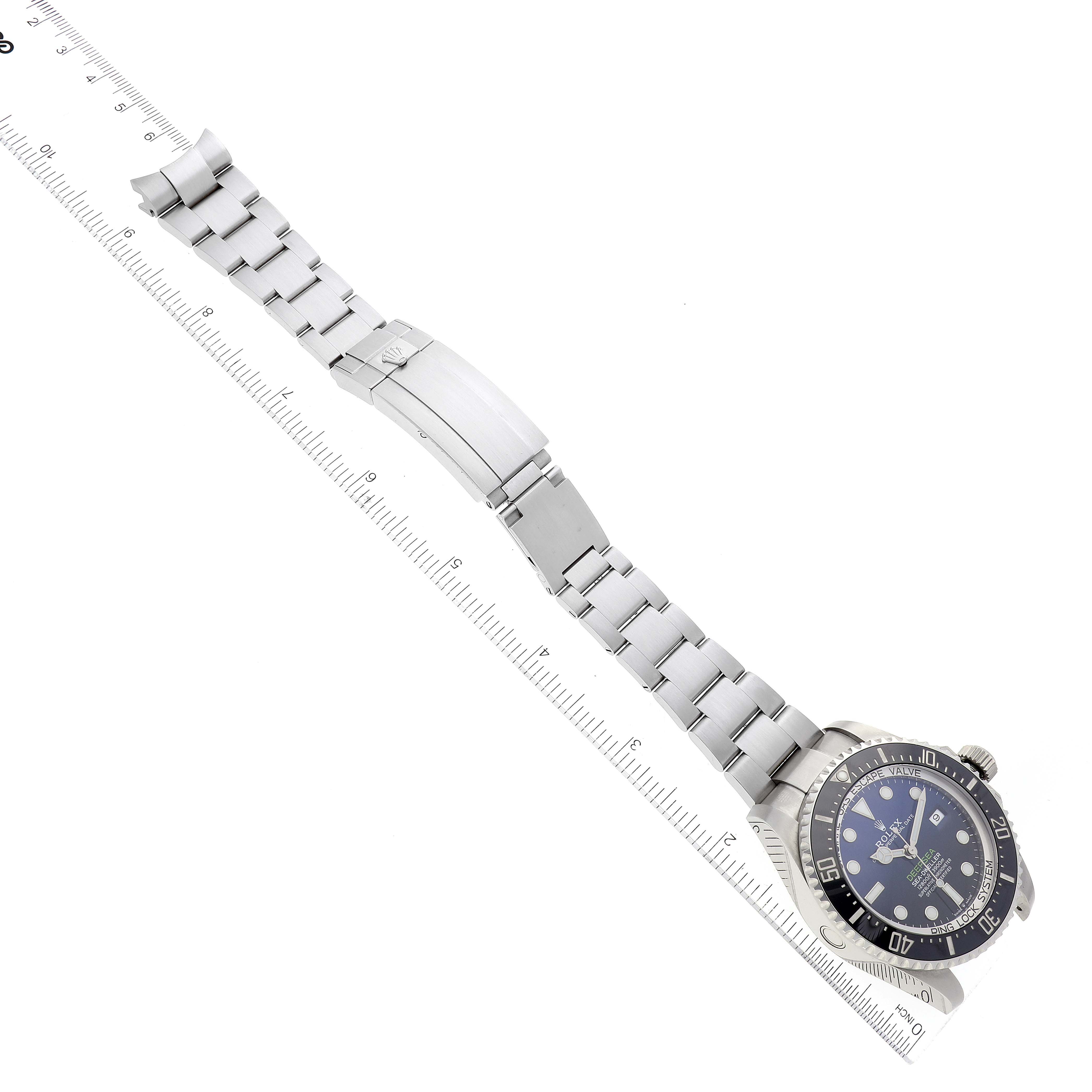 The image shows a Rolex Sea-Dweller 126660 Men's Stainless Steel Blue Dial 126660 Men's Stainless Steel Blue Dial watch laid flat with its bracelet extended beside a ruler for size reference.