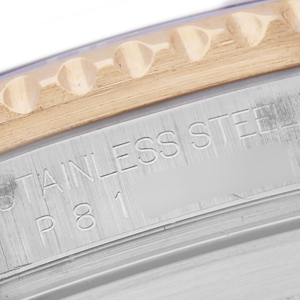 The image shows a close-up of the Rolex Submariner 16613 Men's Steel and Gold (two tone) Blue Dial 16613 Men's Steel and Gold (two tone) Blue Dial's bezel edge and engraved stainless steel part.