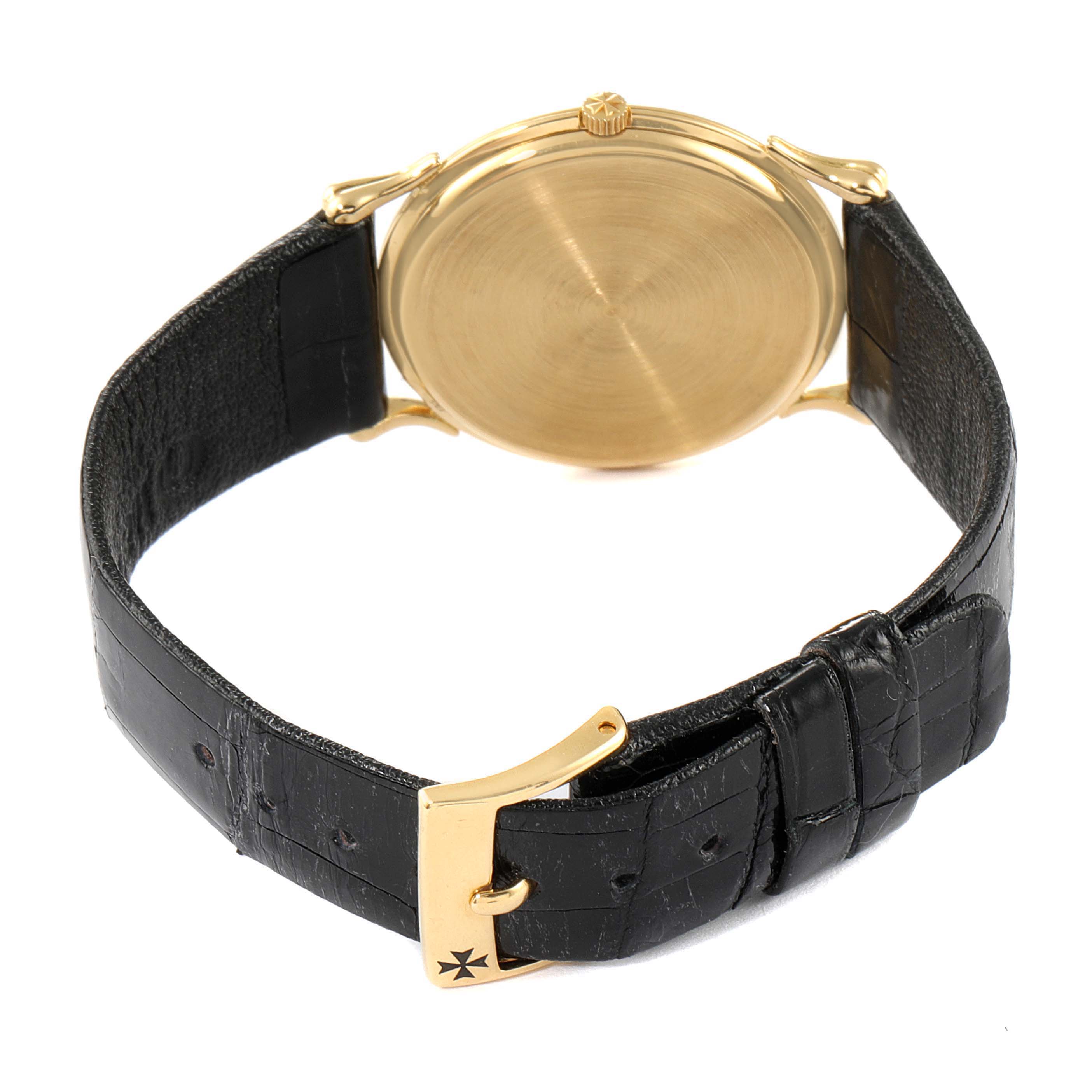 The image shows the back view of a Vintage Vacheron Constantin watch with a gold case and a black leather strap with a gold buckle.