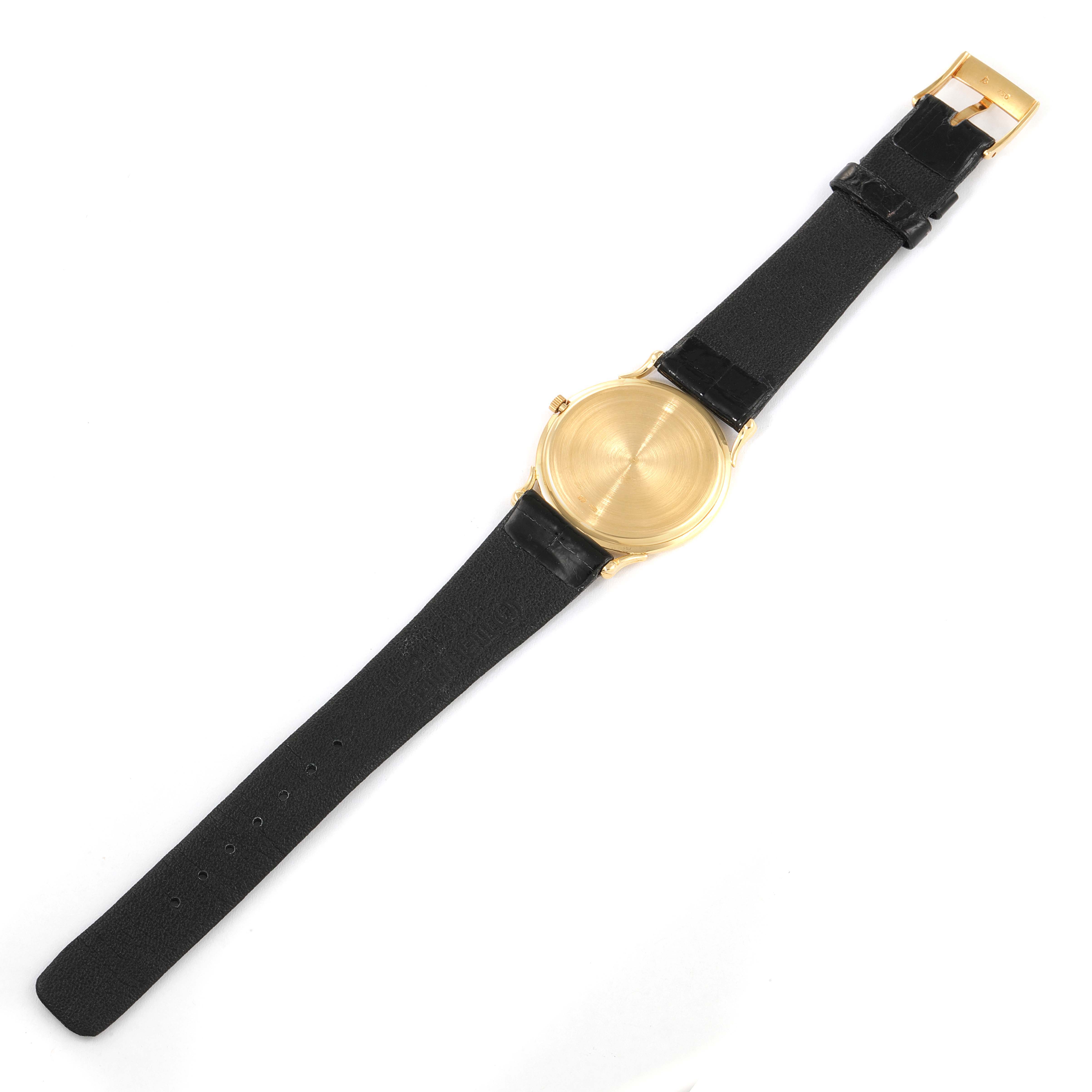 The image shows a Vacheron Constantin Vintage 33216 Men's Yellow Gold White Dial 33216 Men's Yellow Gold White Dial watch from a top-down angle, displaying its black strap, gold case, and buckle.