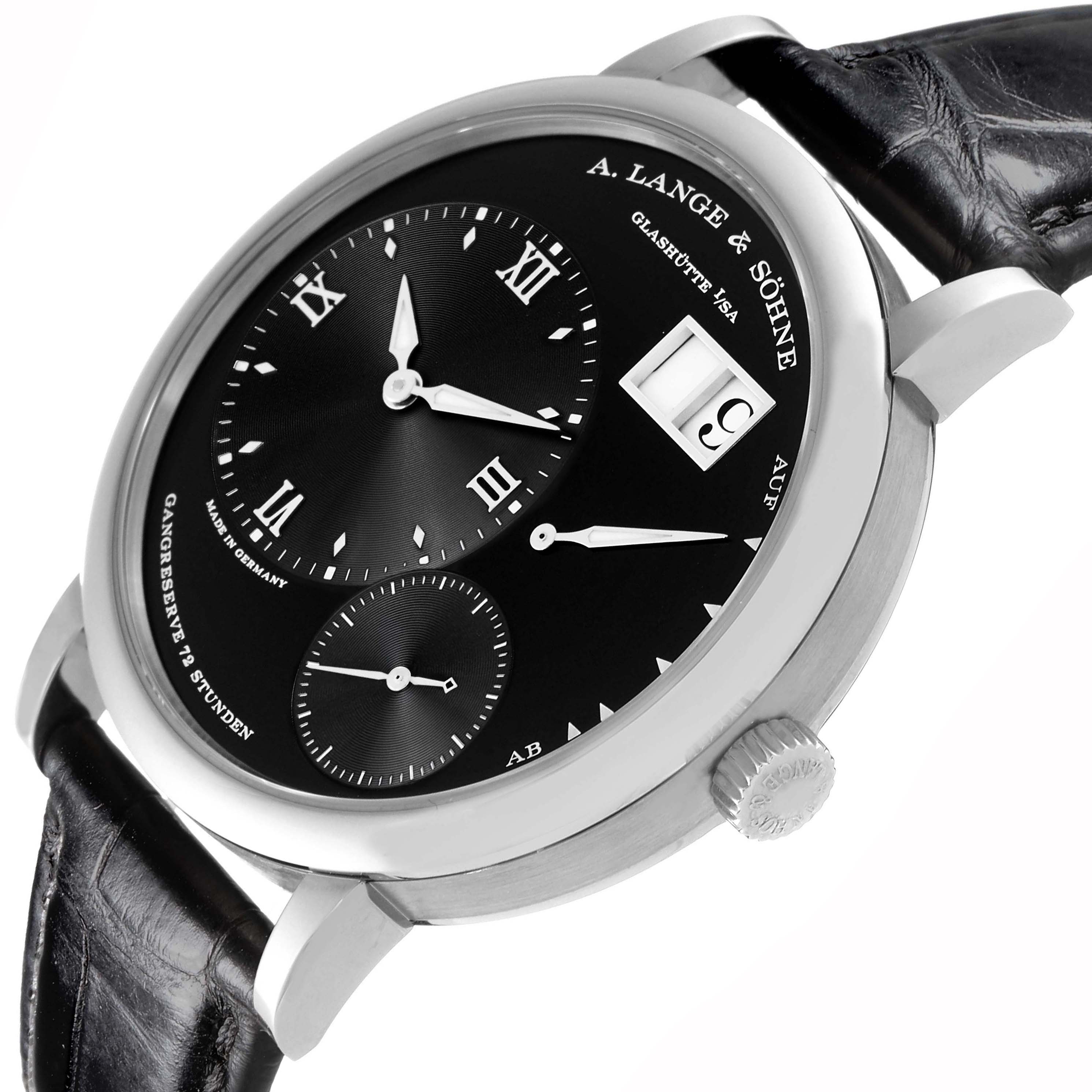 The image shows the A. Lange & Sohne Lange 1 117.028 Men's White Gold Black Dial watch at a tilted angle, highlighting the dial, crown, and strap.