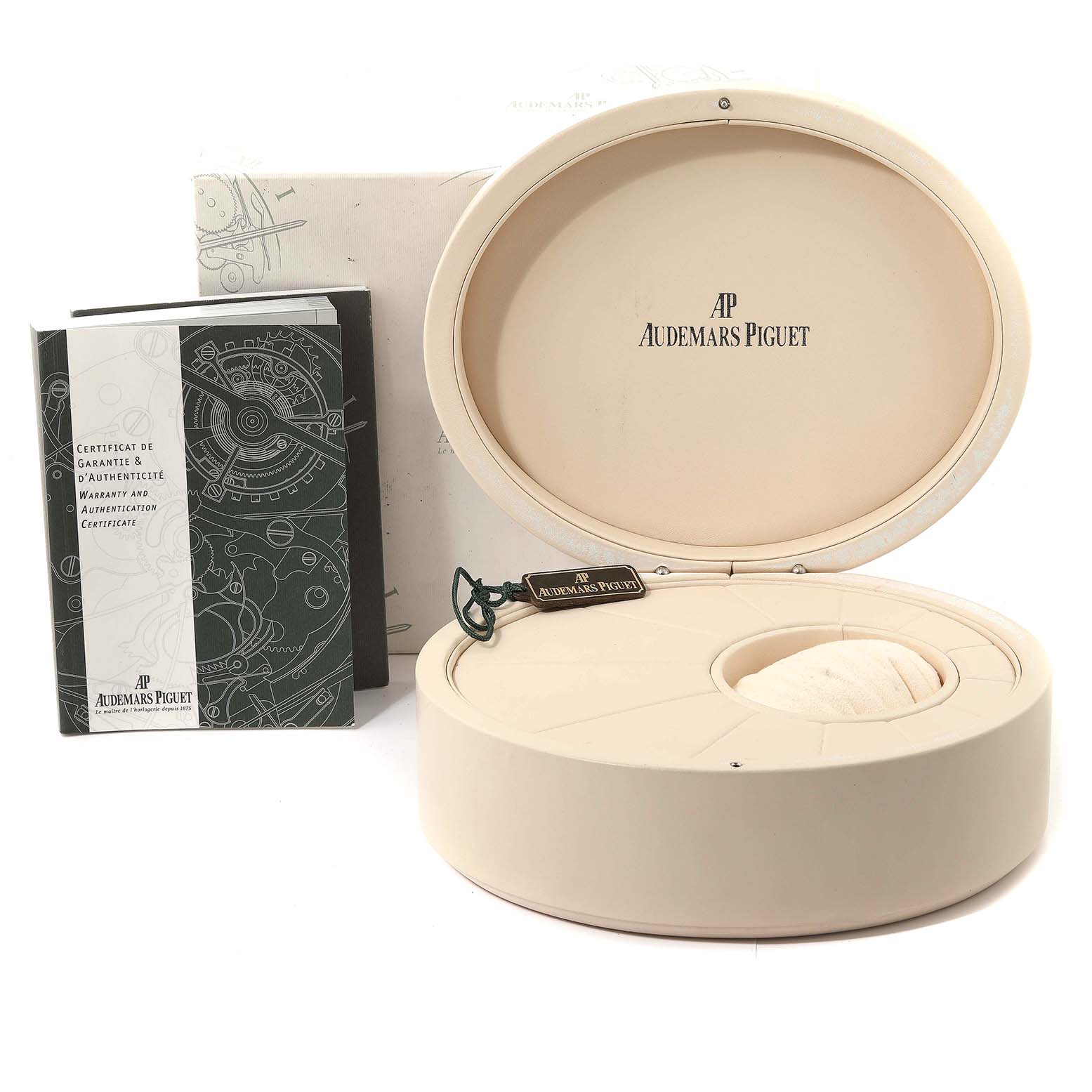 The image shows the open box and packaging for a Millenary model by Audemars Piguet, including the warranty booklet and a tag.