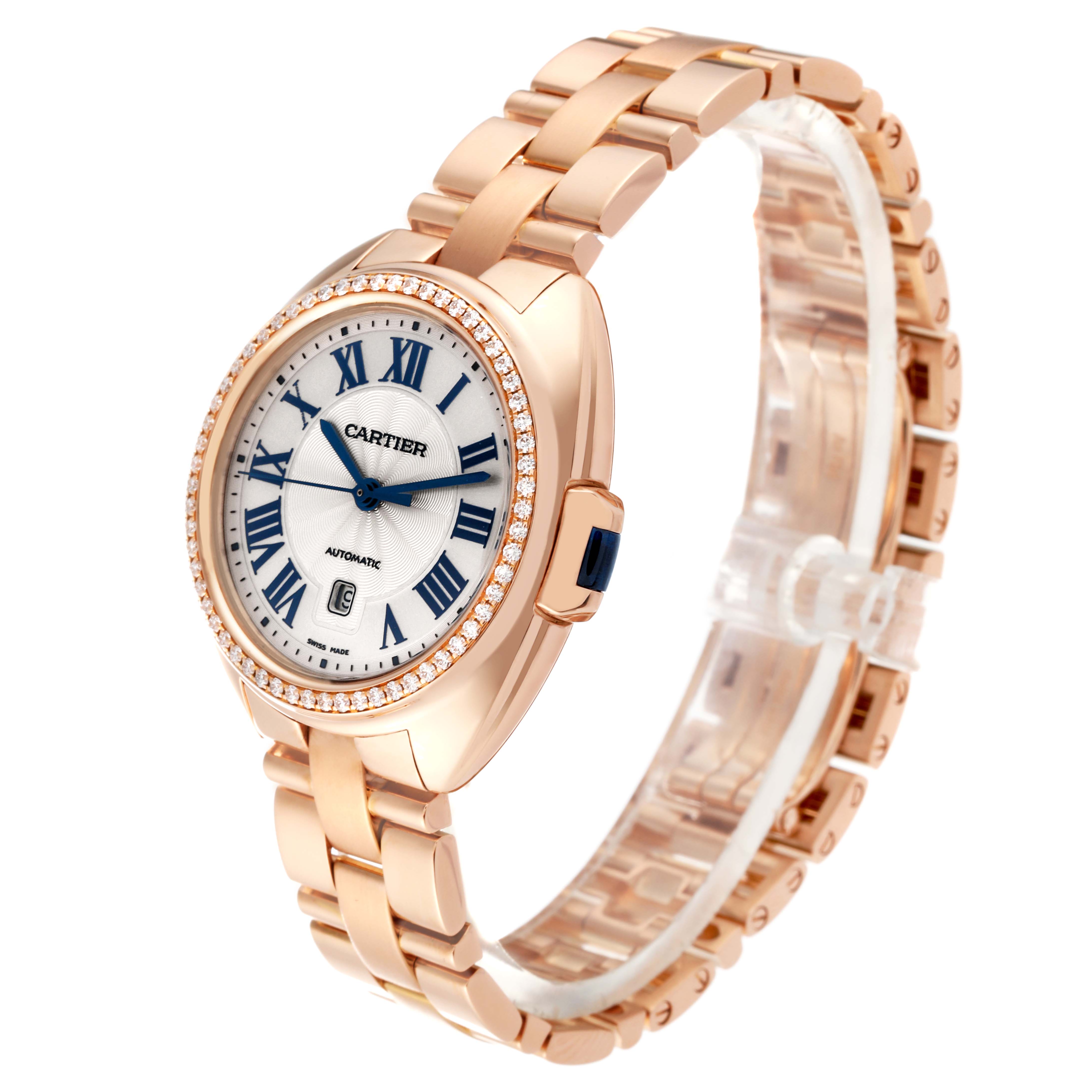 The Cartier Clé watch is shown at a 3/4 angle, displaying the face, bezel, crown, and metallic bracelet.