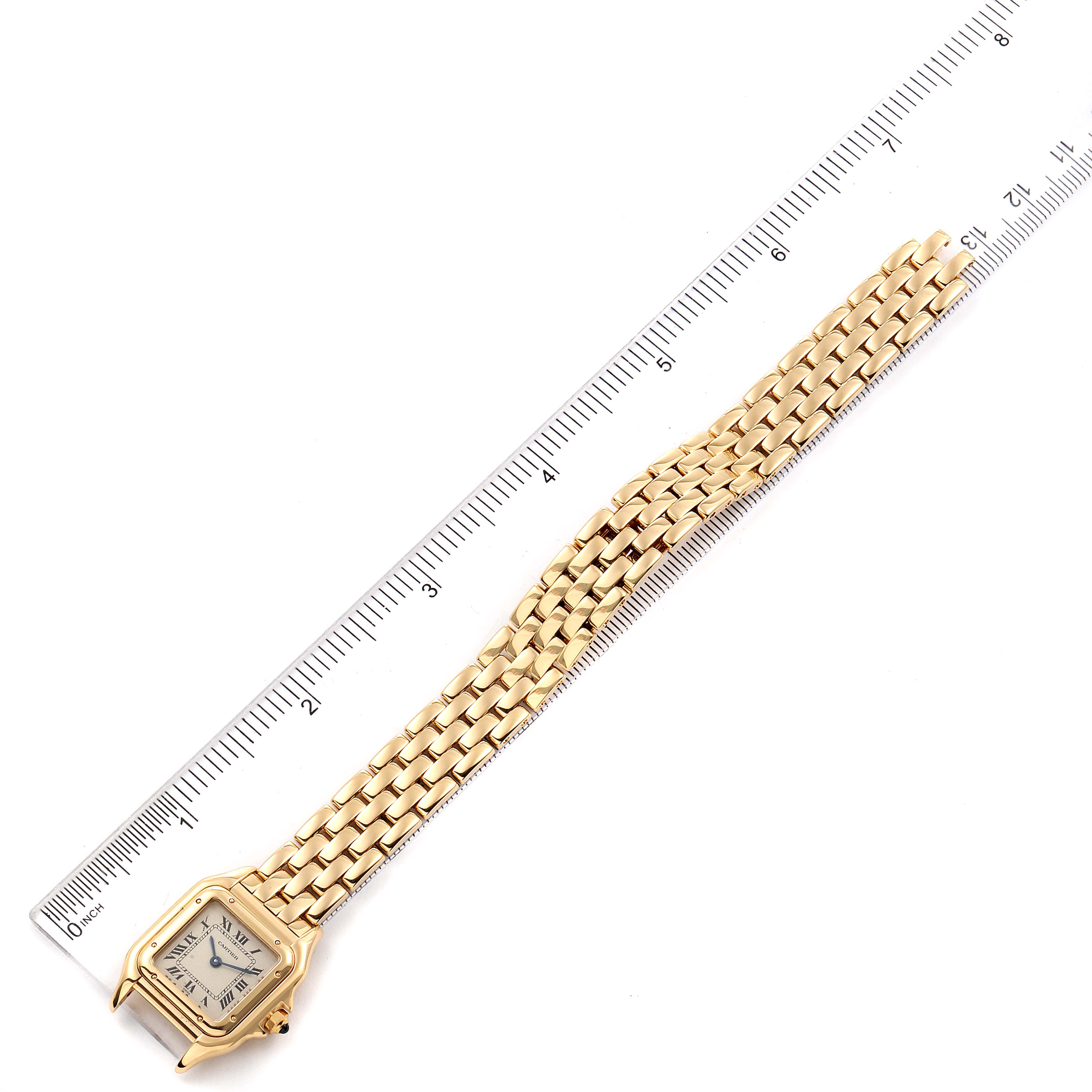 The image shows a Panthere de Cartier watch laid flat beside a ruler, displaying its face and full bracelet.
