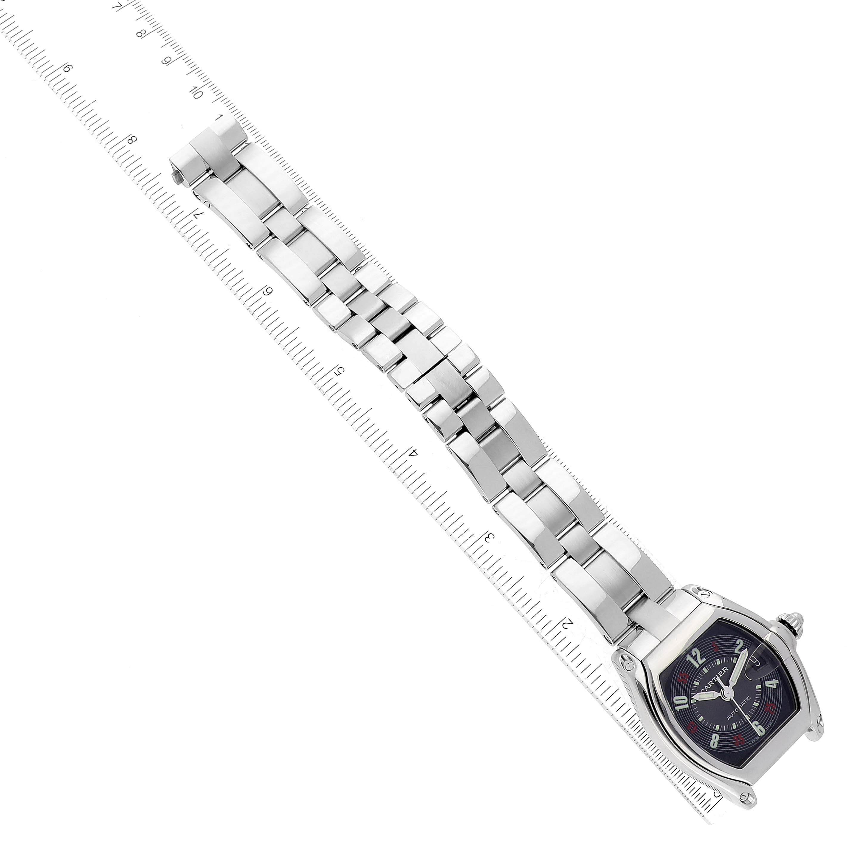 The image shows a Cartier Roadster W62002V3 Men's Stainless Steel Black Dial W62002V3 Men's Stainless Steel Black Dial watch laid flat with its metal bracelet and a ruler for scale.