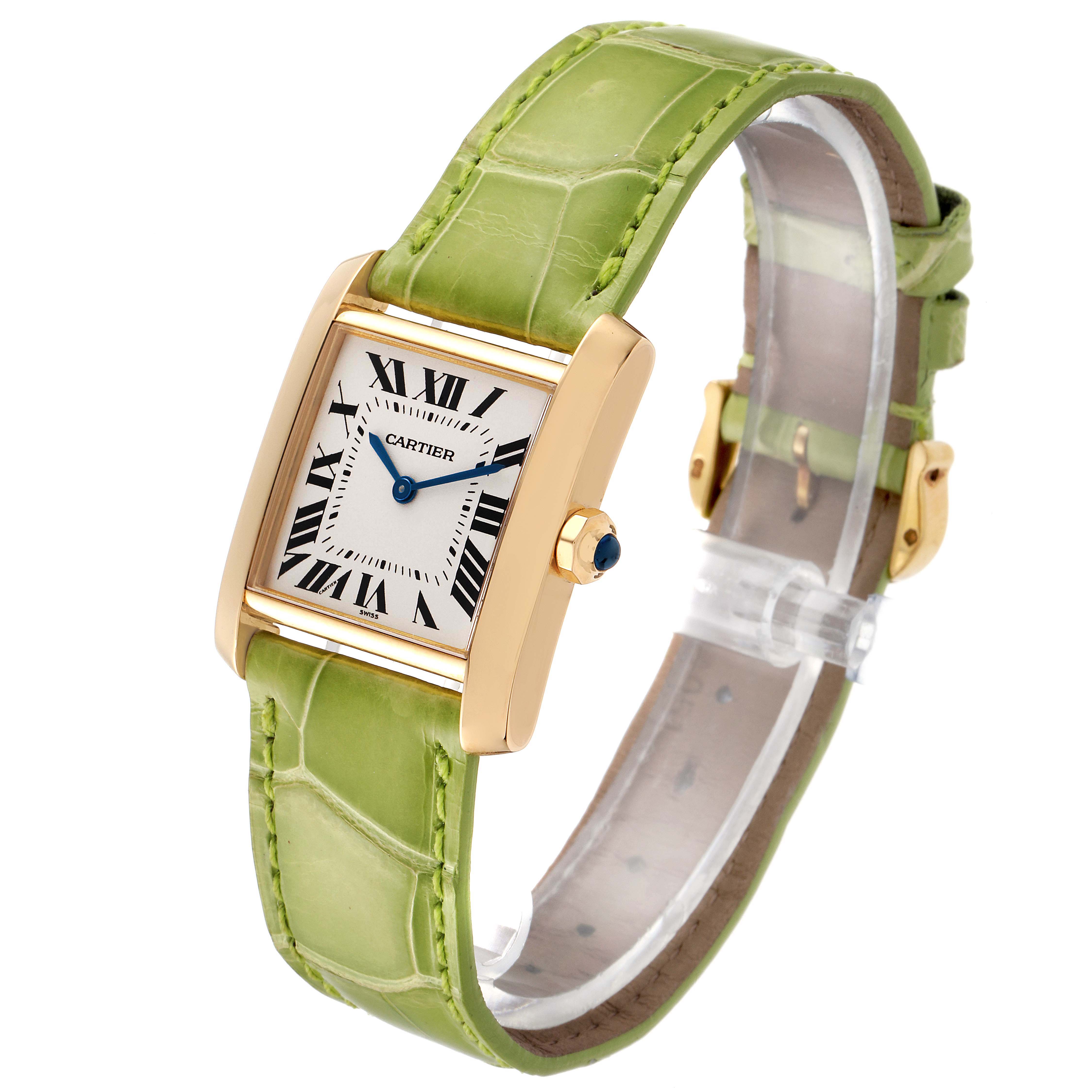 The Cartier Tank Française watch is shown at a three-quarter angle, displaying its rectangular dial, gold case, and green leather strap.