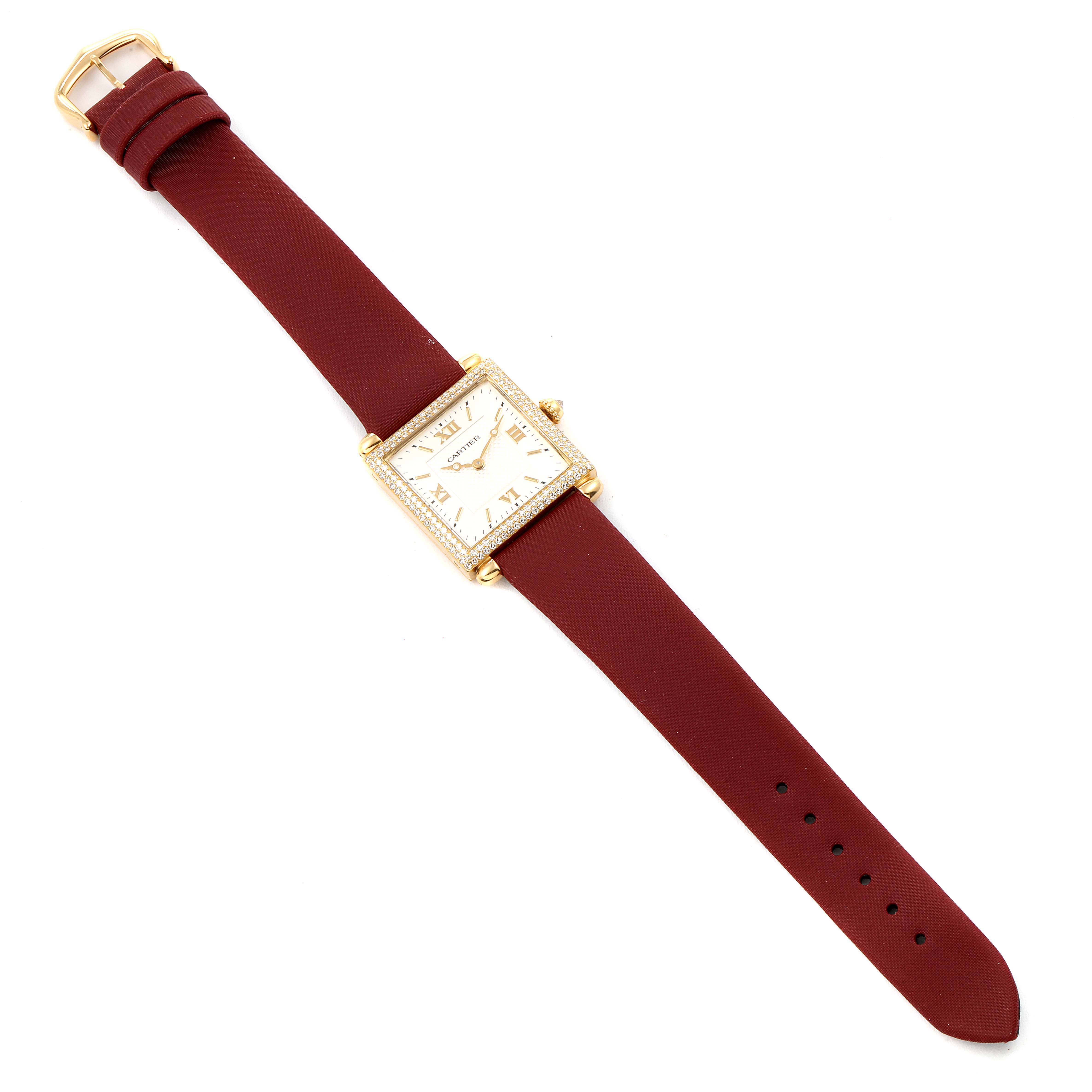 The Cartier Tank Obus WB800351  Women's Yellow Gold Silver Dial WB800351  Women's Yellow Gold Silver Dial watch is shown from a top-down angle, displaying its face, bezel, case, red strap, and buckle.