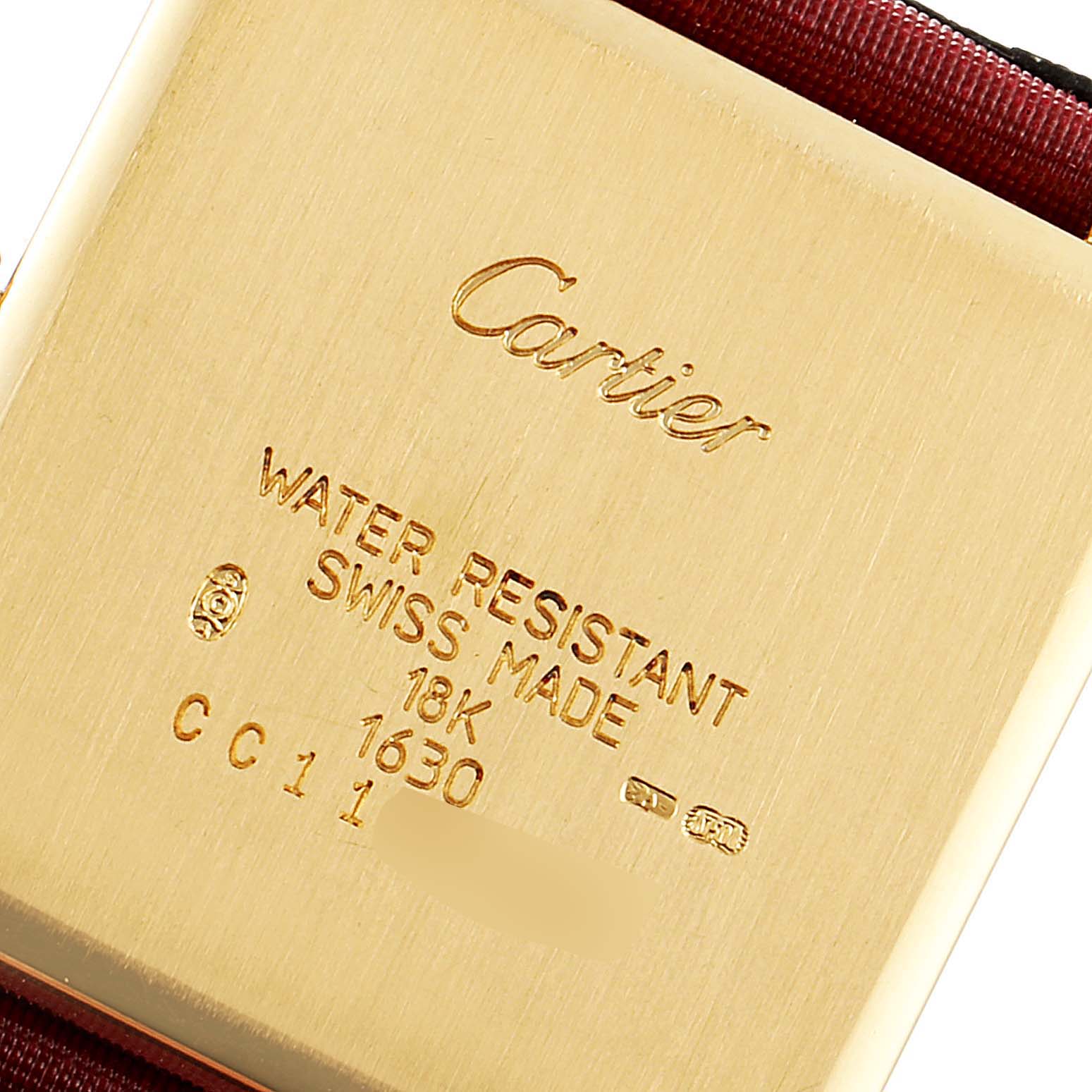 This image shows the back of a Cartier Tank Obus WB800351  Women's Yellow Gold Silver Dial WB800351  Women's Yellow Gold Silver Dial watch, highlighting its water resistance, Swiss make, and 18K gold mark.