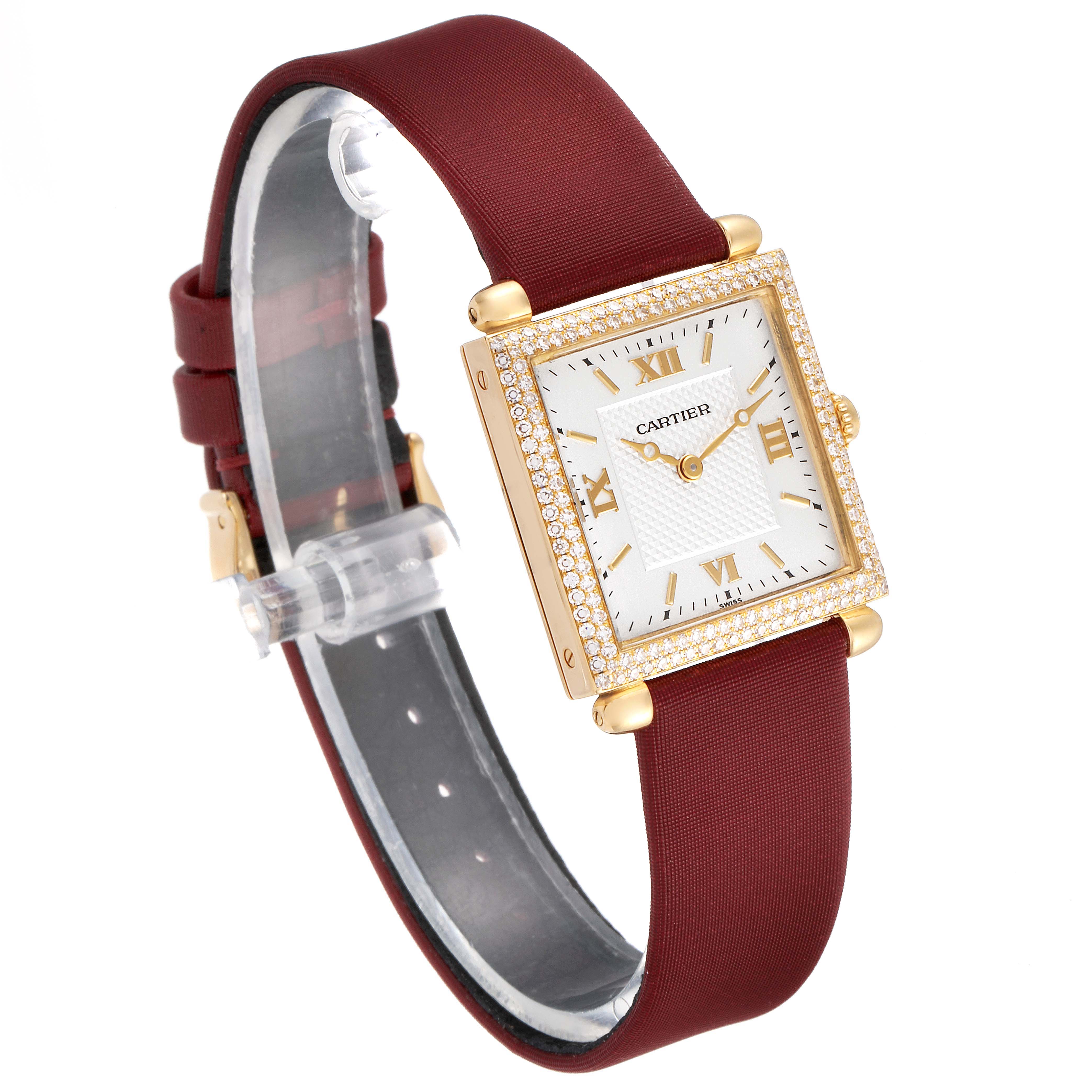 This image shows a Cartier Tank Obus WB800351  Women's Yellow Gold Silver Dial WB800351  Women's Yellow Gold Silver Dial watch at an angle, highlighting the face, bezel, and burgundy strap.