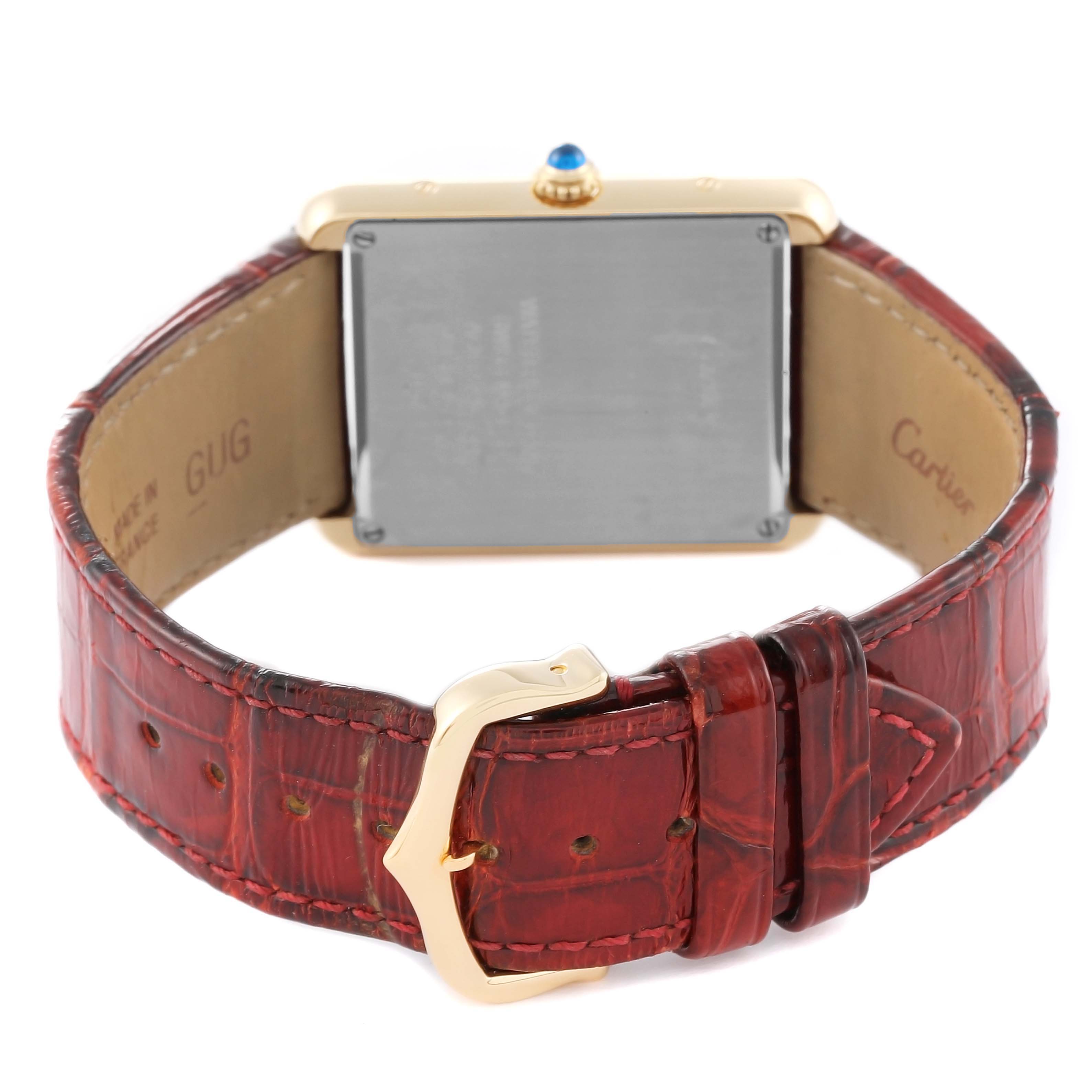 The image shows the back view of a Cartier Tank Solo W5200004 Men's Yellow Gold Silver Dial W5200004 Men's Yellow Gold Silver Dial watch, including its red leather strap and gold buckle.