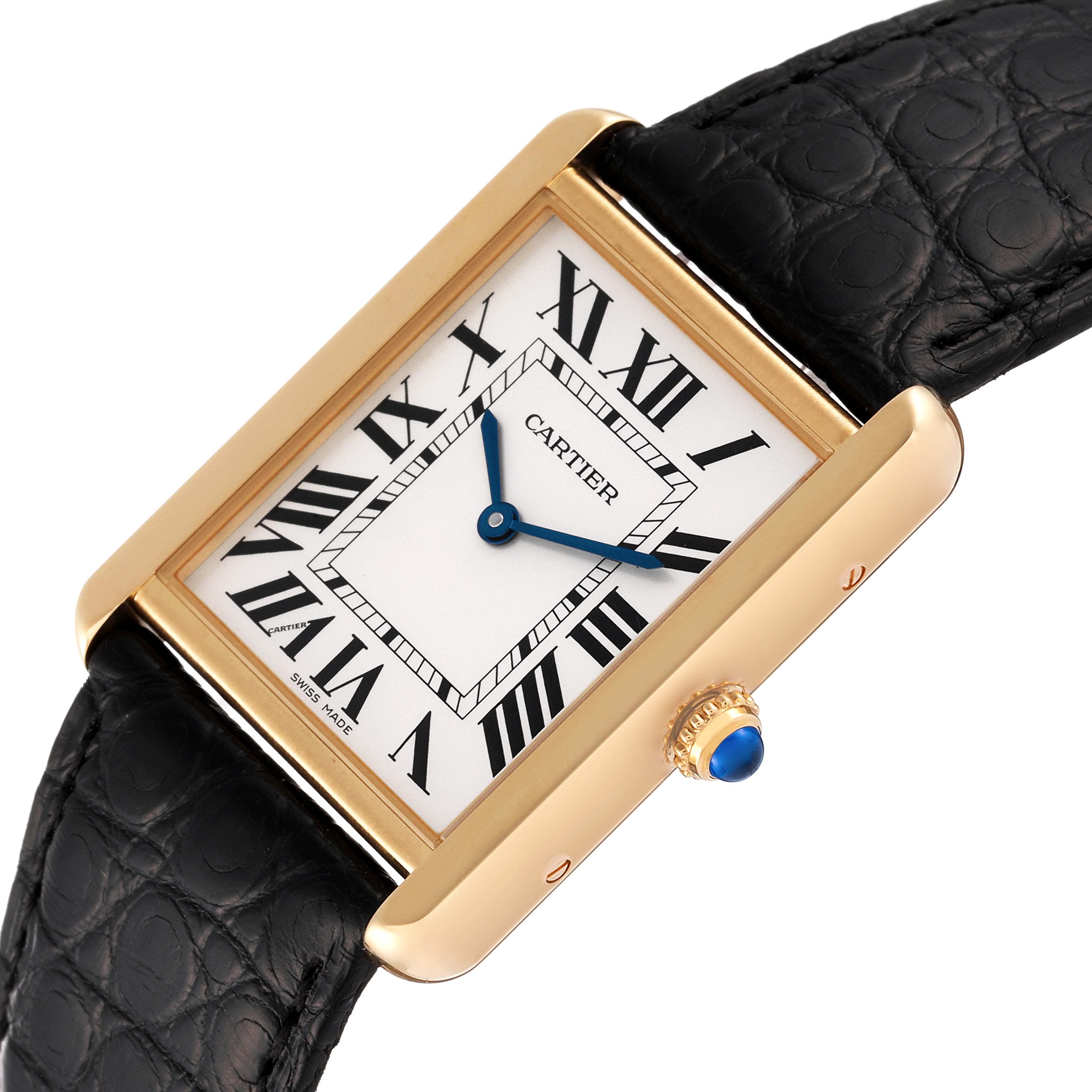 The image shows a Cartier Tank Solo W5200004 Men
s Yellow Gold Silver Dial W5200004 Men
s Yellow Gold Silver Dial watch at an angle showcasing its white dial, Roman numerals, blue hands, and black leather strap.