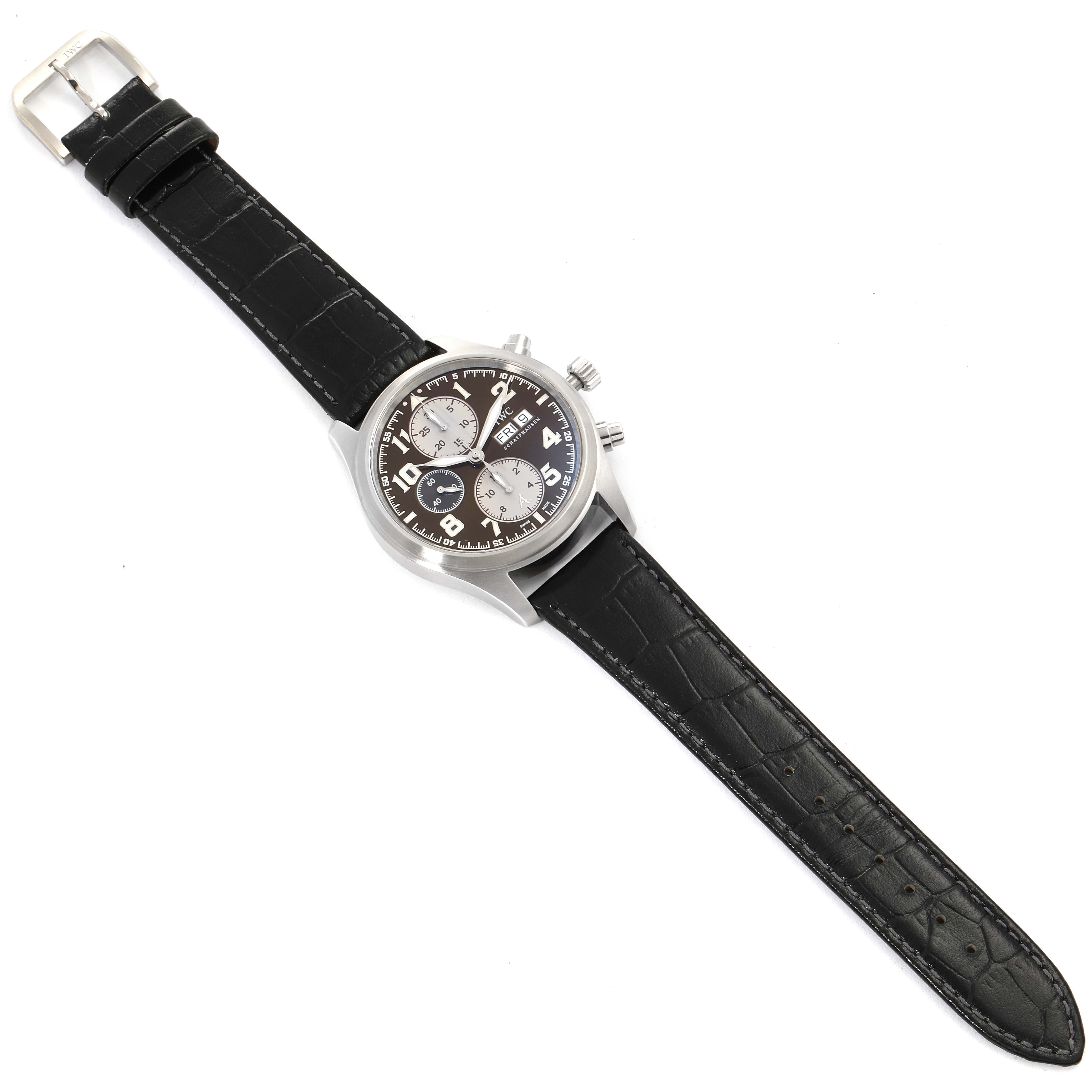 The image shows the IWC Pilot IW371709 Men's Stainless Steel Brown Dial IW371709 Men's Stainless Steel Brown Dial model watch at an angled top view, featuring its black leather strap, silver case, and dial with subdials.