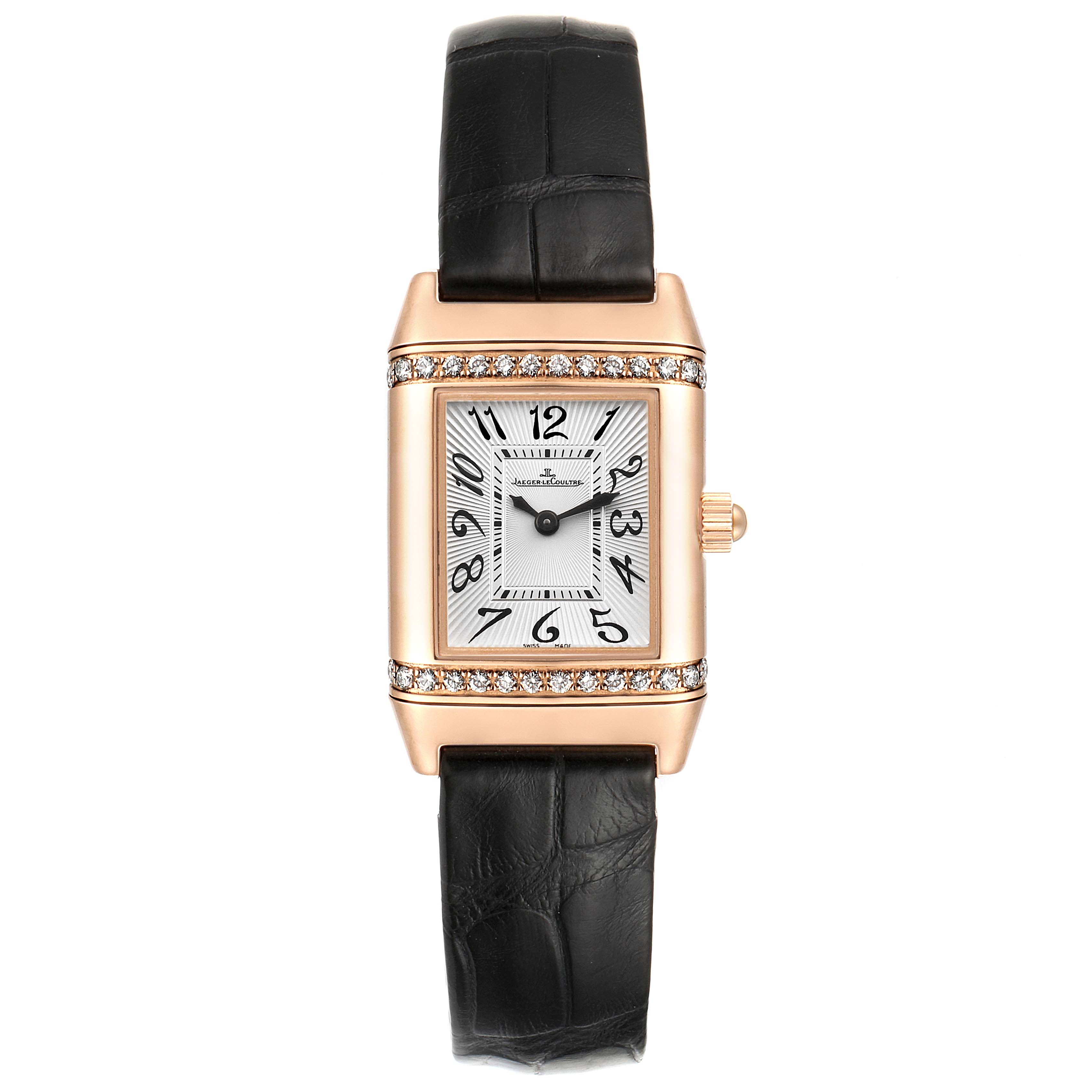 This image shows a front view of a Jaeger LeCoultre Reverso Q2651430 Women's Rose Gold Silver Dial Q2651430 Women's Rose Gold Silver Dial watch with a black leather strap and a diamond-studded rectangular case.