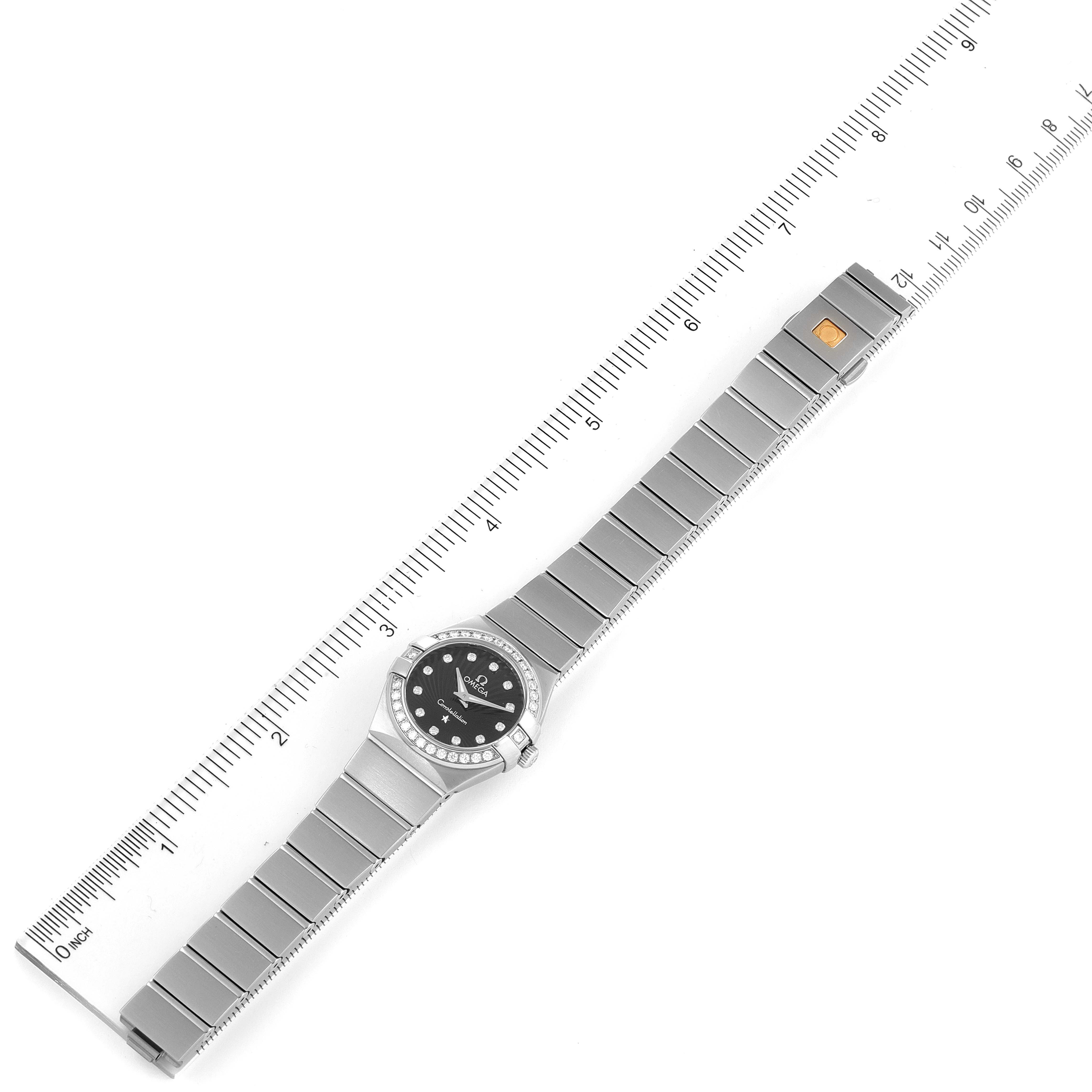 The Omega 123.15.24.60.51.001 Women's Stainless Steel Black Dial 123.15.24.60.51.001 Women's Stainless Steel Black Dial Constellation 24 Black Dial Diamond Steel Watch model 123.15.24.60.51.001 is shown from an overhead angle, fully extended alongside a ruler.