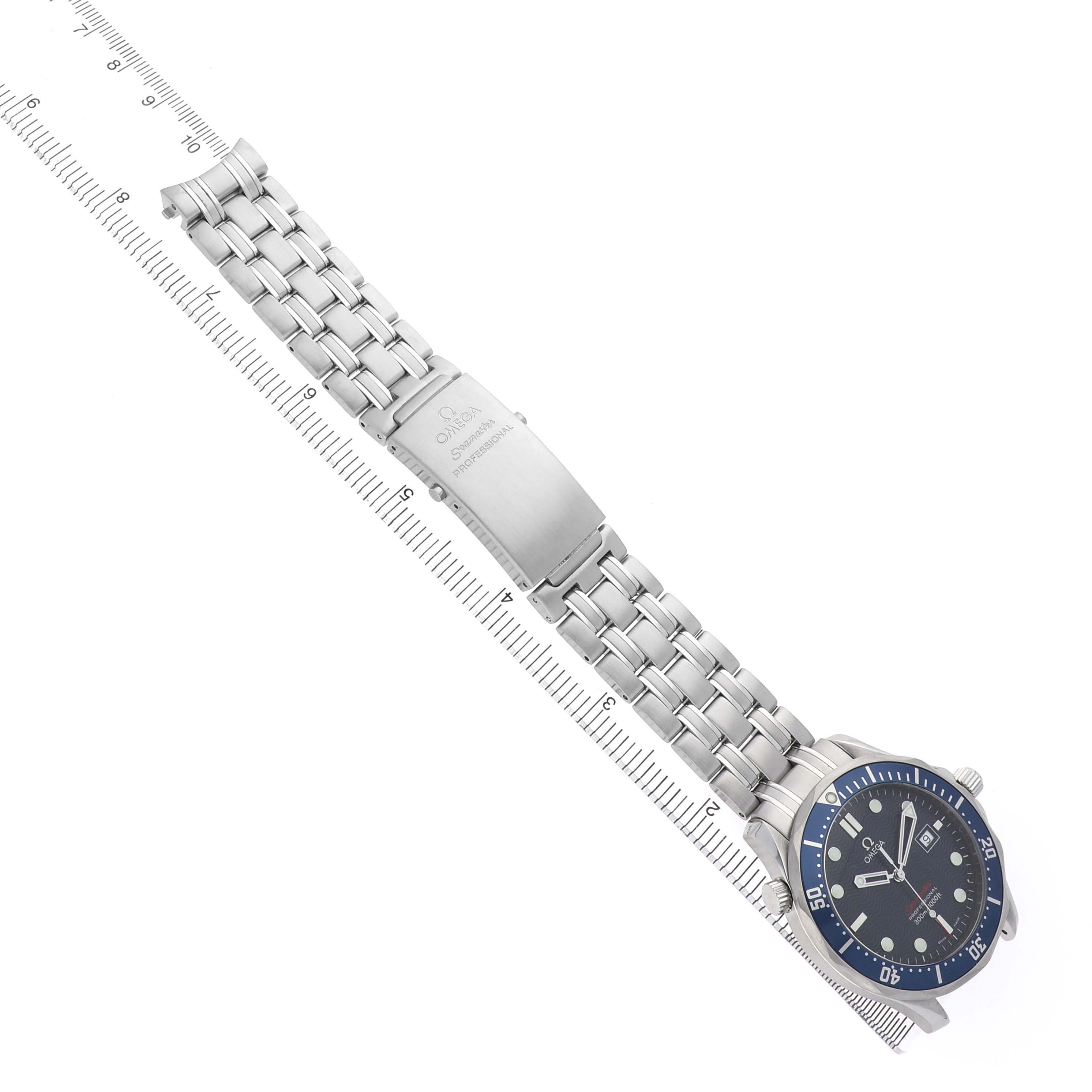 The Omega Seamaster 2221.80.00 Men's Stainless Steel Blue Dial watch is shown diagonally with its face, bracelet, and clasp clearly visible next to a ruler.