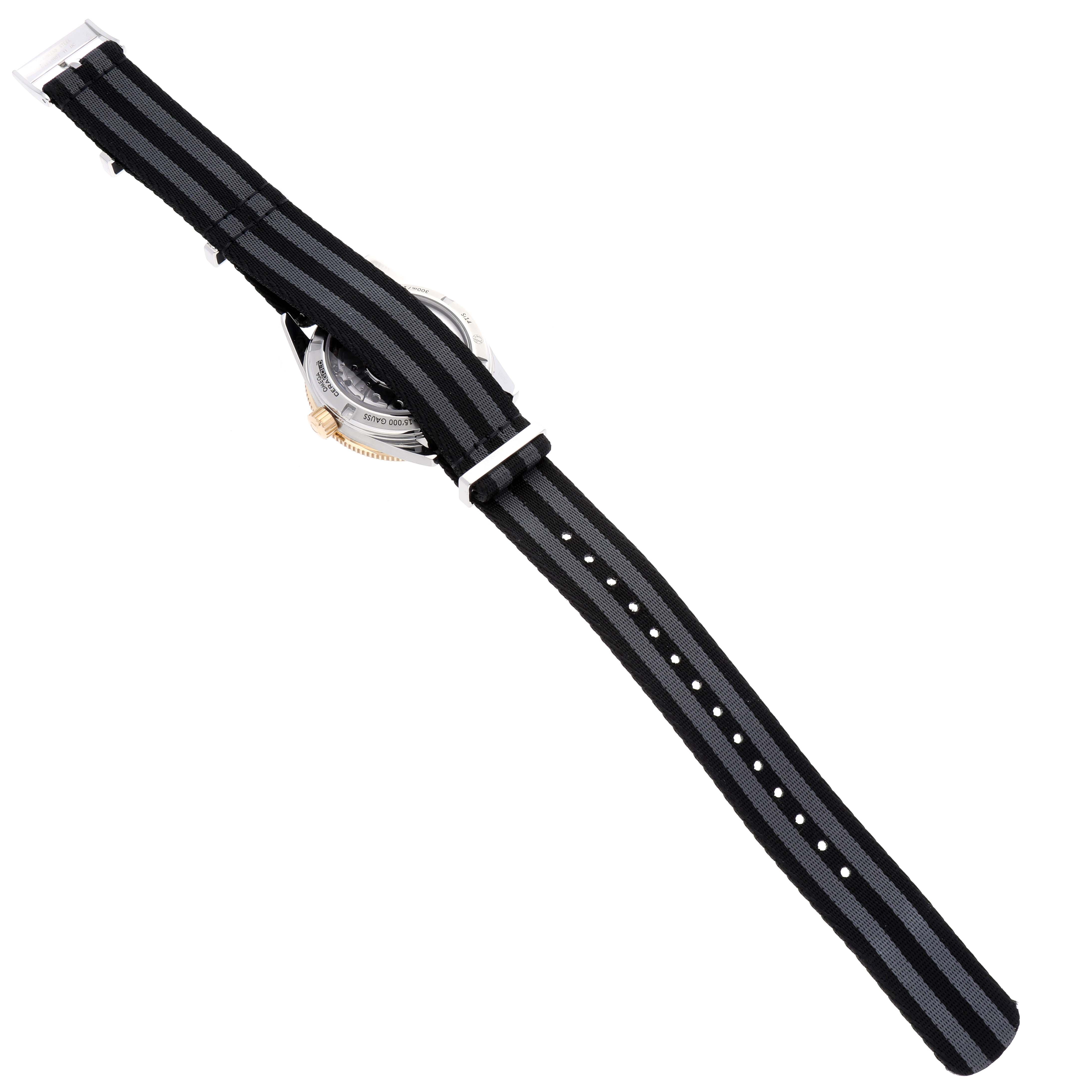 The image shows the back side and strap of an Omega Seamaster 233.22.41.21.01.001 Men's Steel and Gold (two tone) Black Dial 233.22.41.21.01.001 Men's Steel and Gold (two tone) Black Dial watch, highlighting its striped nylon band.