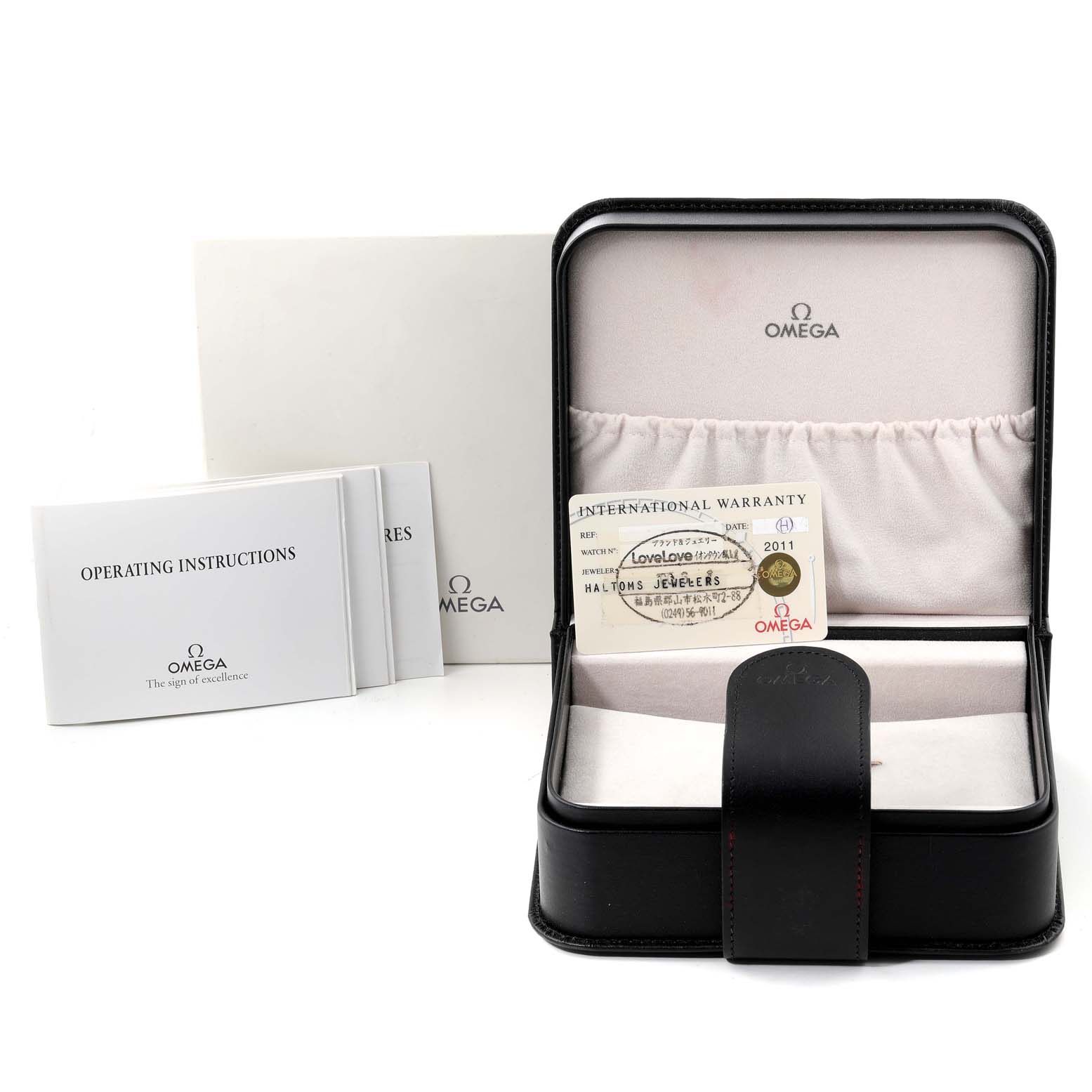 The image shows the open box and documentation for an Omega Speedmaster 3572.50.00 Men
s Stainless Steel Black Dial 3572.50.00 Men
s Stainless Steel Black Dial watch, including the operating instructions and warranty card.