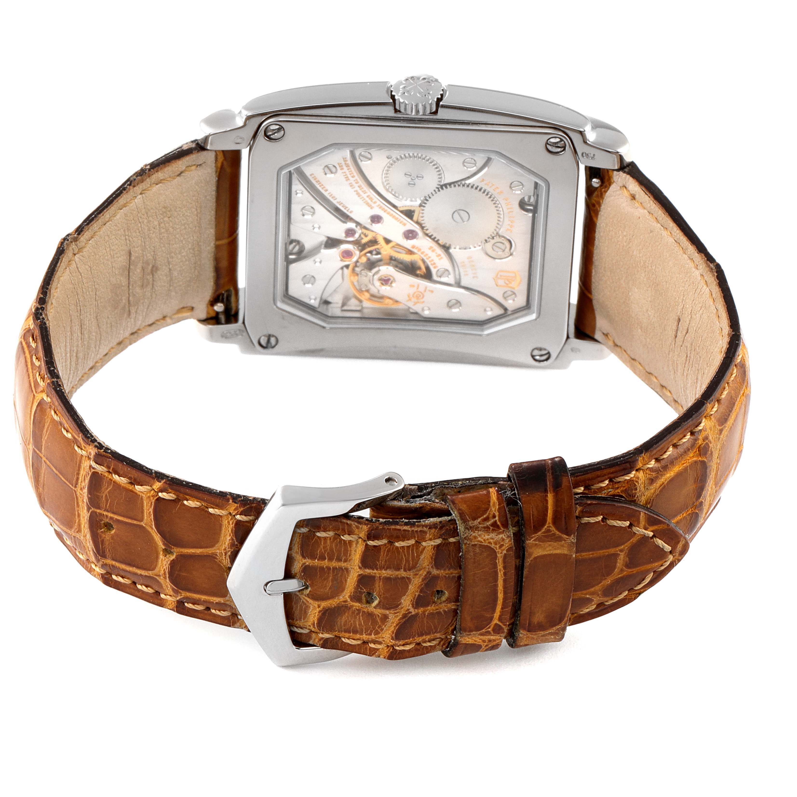 The image shows the back of a Patek Philippe Gondolo 5124G-001 Men's White Gold Pink Dial 5124G-001 Men's White Gold Pink Dial watch, highlighting its mechanical movement and brown leather strap.