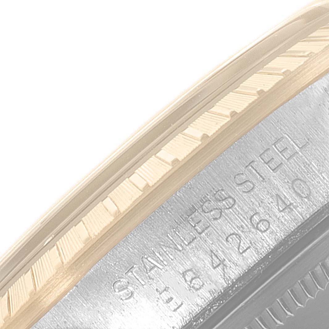 This image shows a close-up of the bezel and case side of a Rolex Date 15223 Men's Steel and Gold (two tone) Silver Dial 15223 Men's Steel and Gold (two tone) Silver Dial watch, highlighting the ridged bezel and "STAINLESS STEEL" engraving.