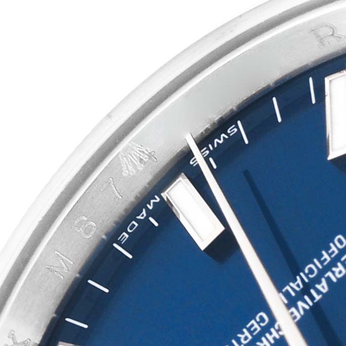 The image shows a close-up of the dial and bezel of a Rolex Date 115210 Men's Stainless Steel Blue Dial 115210 Men's Stainless Steel Blue Dial model watch, highlighting the "Swiss Made" text and part of the markers.